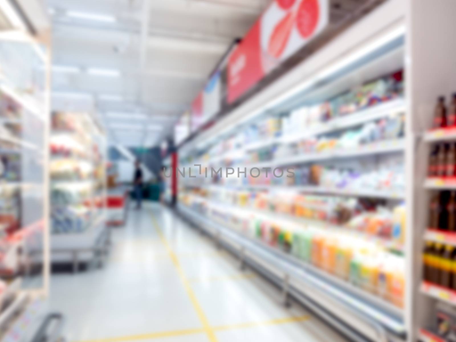 Supermarket blur background. Blurred interior view with walkway between cold drink beverage product shelves in shopping mall.
