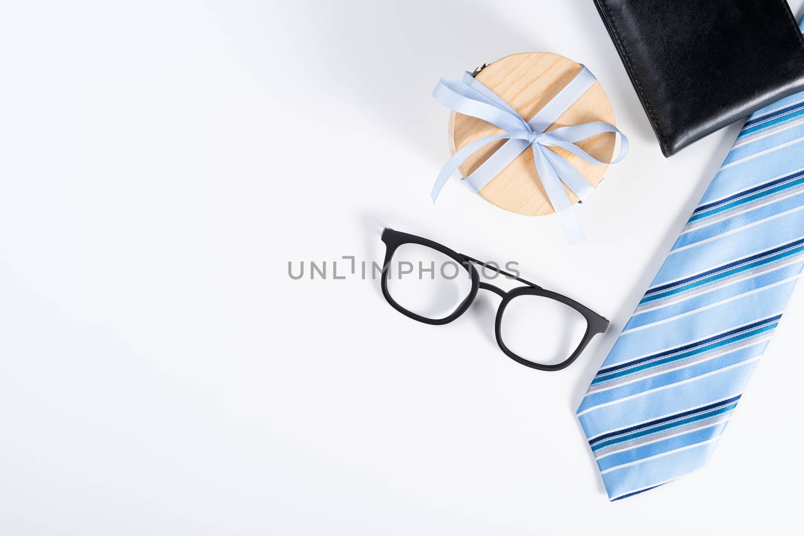 Happy Father Day background concept with blue necktie, glasses, wallet and gift box on white background with copy space for text.