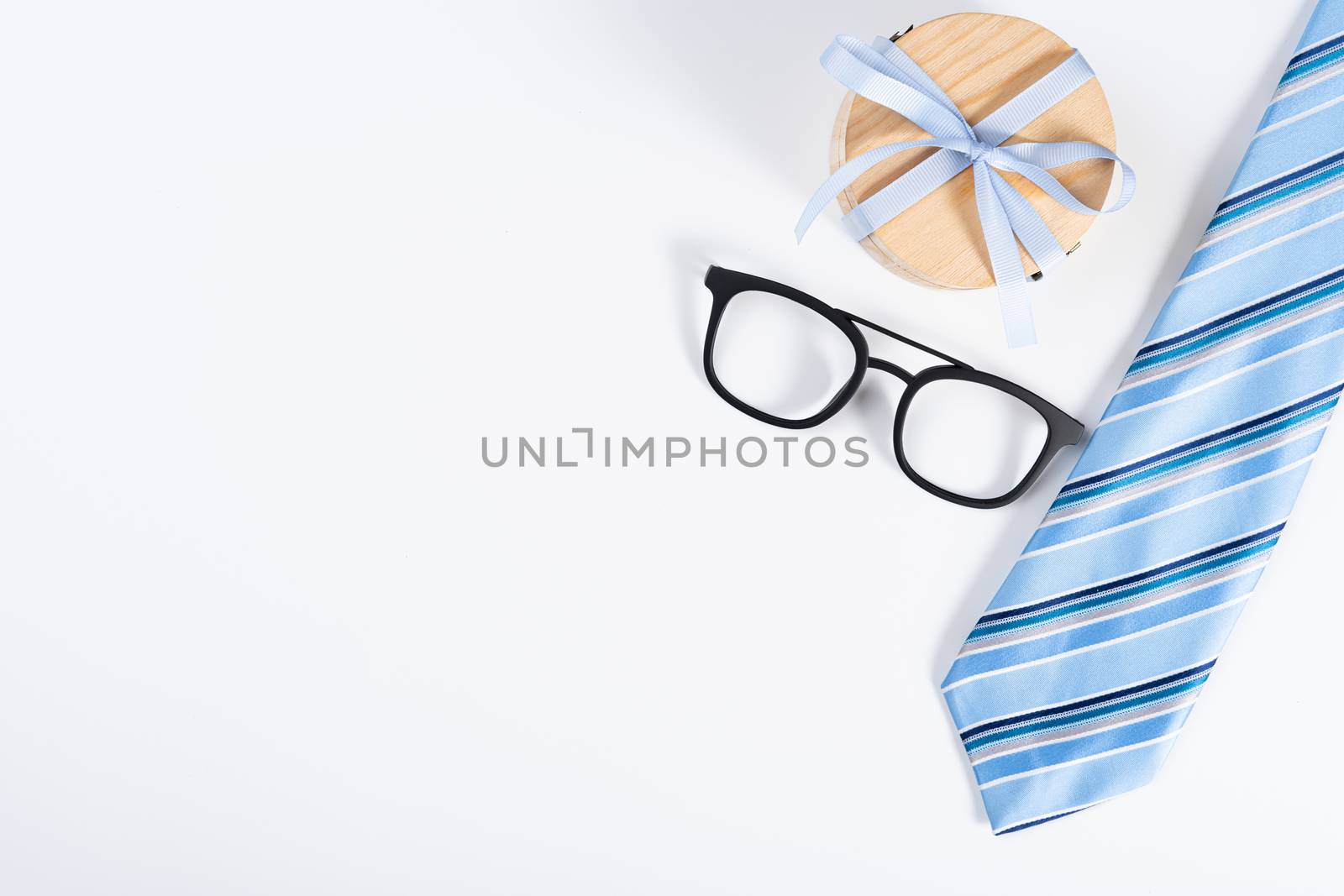Happy Father Day background concept with blue necktie, glasses and gift box on white background with copy space for text.