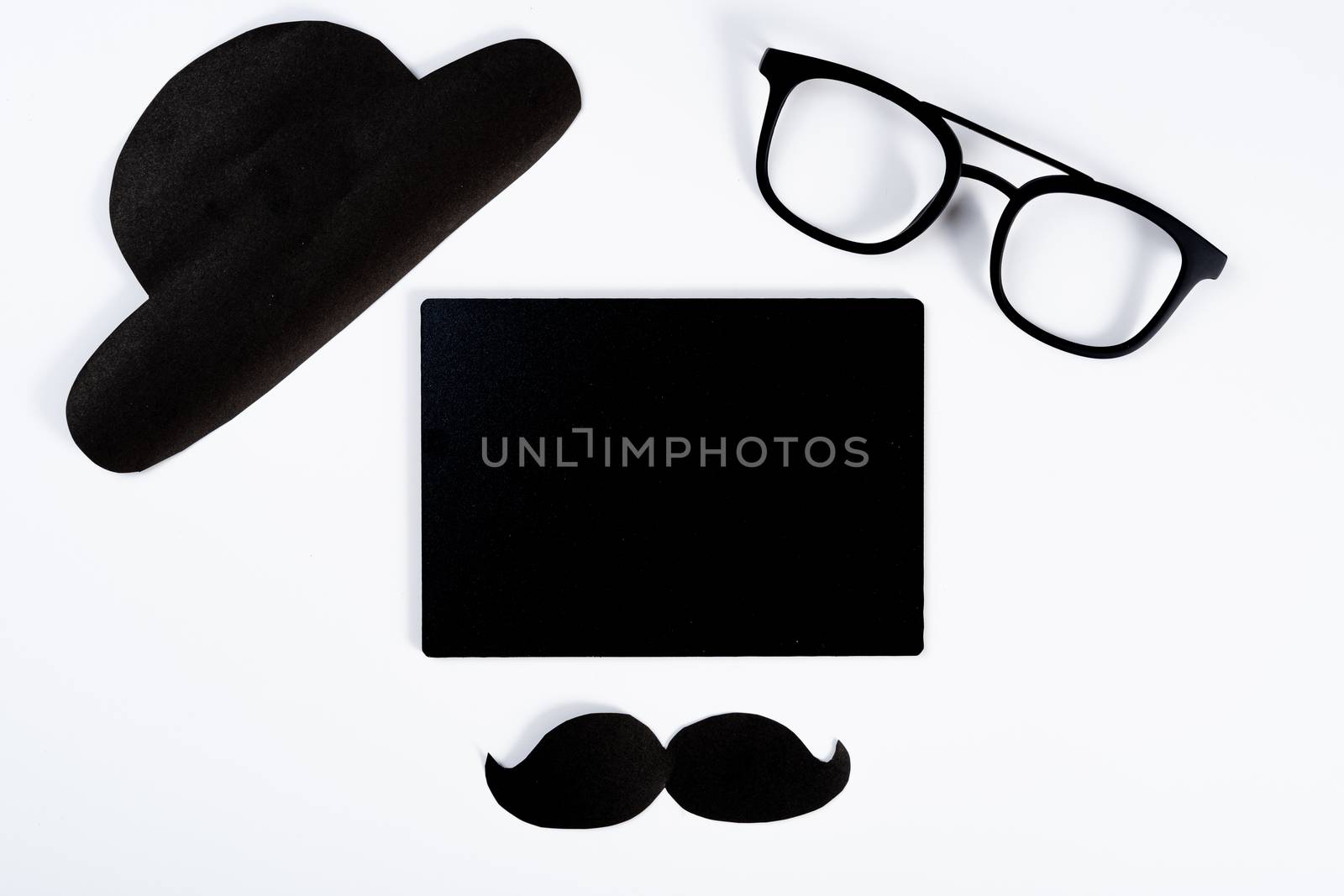 Happy Father Day background concept with blackboard and paper cut of hat, glasses and black mustache on white background with copy space for text.