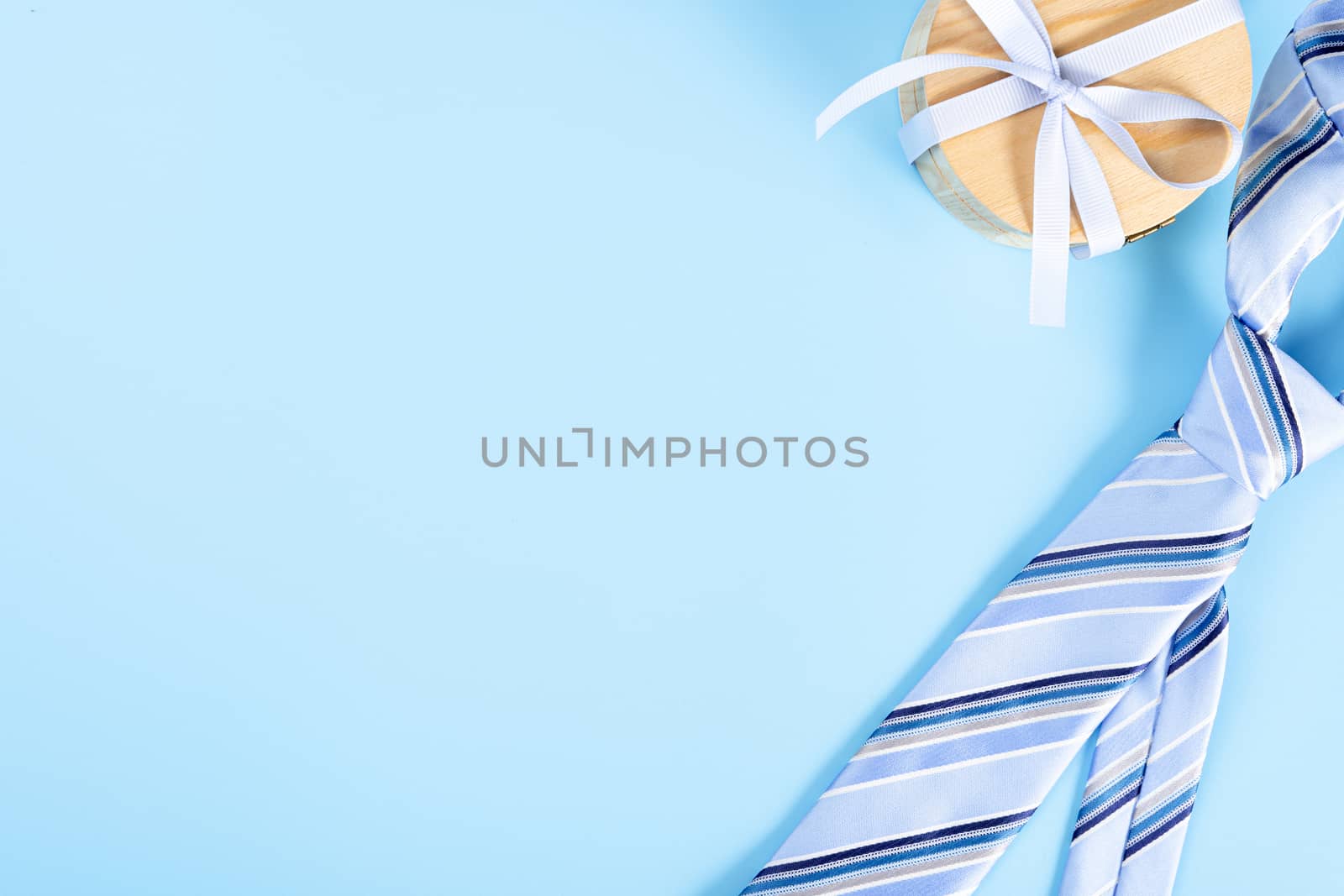 Happy Father Day background concept with blue necktie and gift box on blue background with copy space for text.