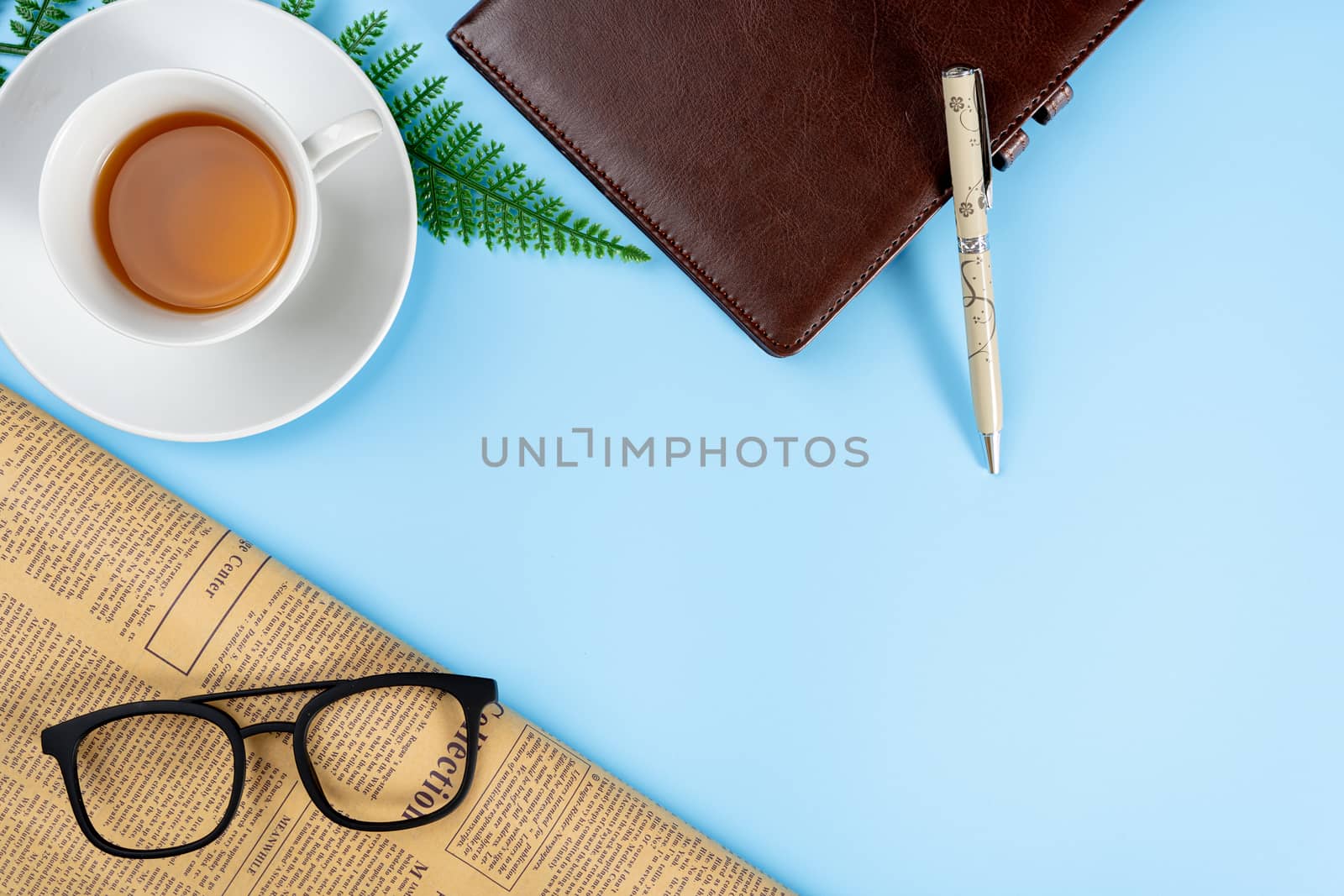 Happy Father Day background concept with notebook, pen, leaf, cup of tea, glasses and newspaper on blue background with copy space for text.