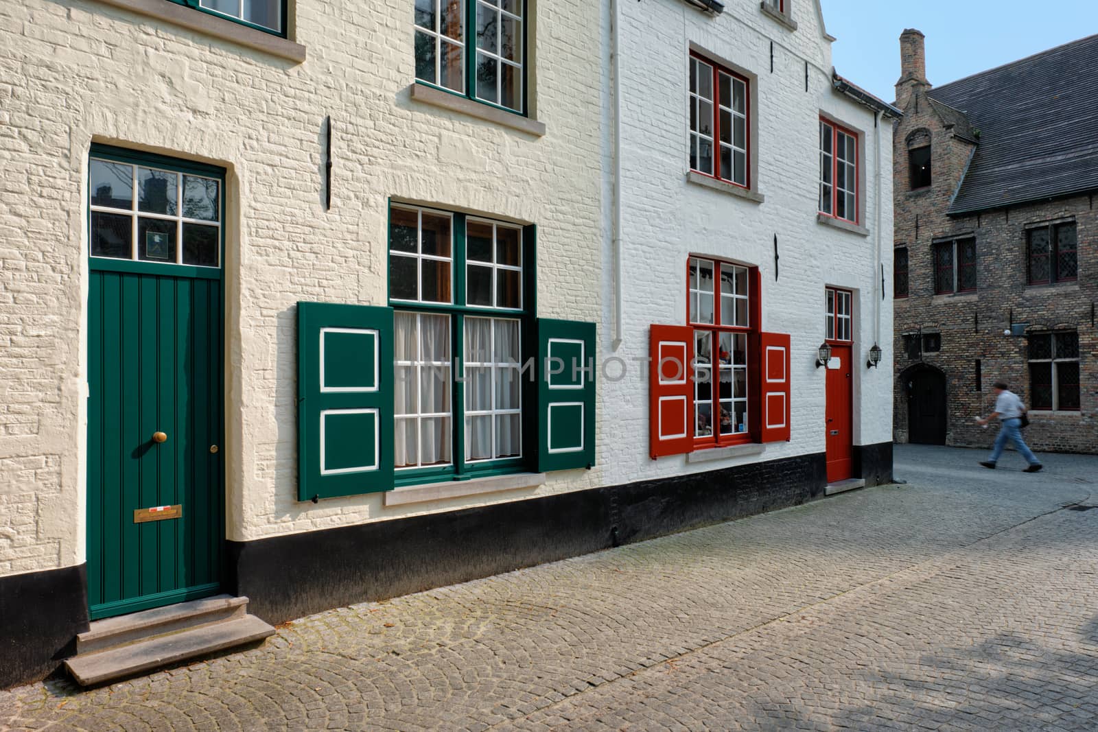 Door and window of an old house and street with motion blurred man, Bruges (Brugge), Belgium