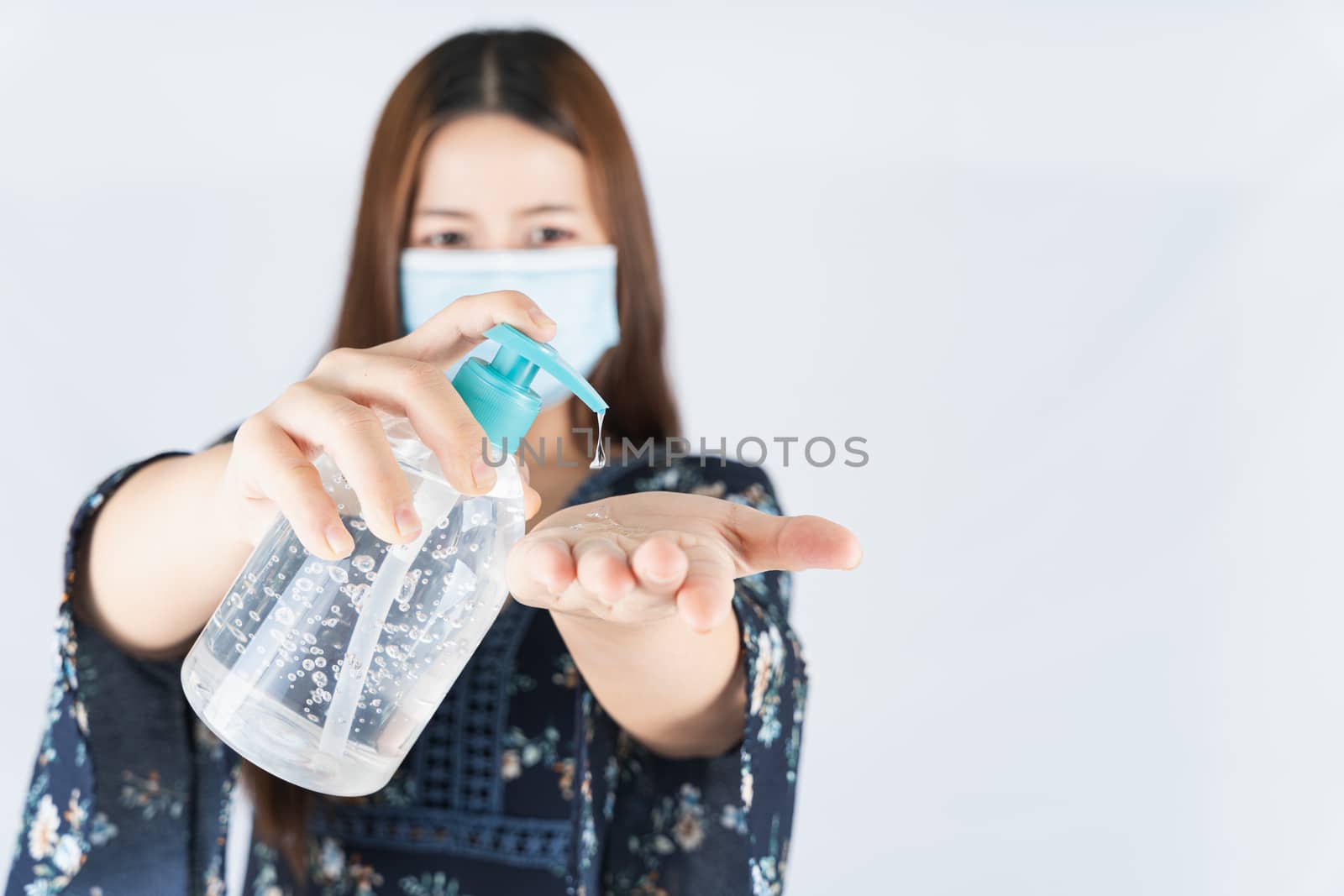 Asian beautiful happy hipster woman wearing a medical protection face mask for protect the coronavirus, filter dust PM 2.5 and cold and using sanitizer hand gel on white background