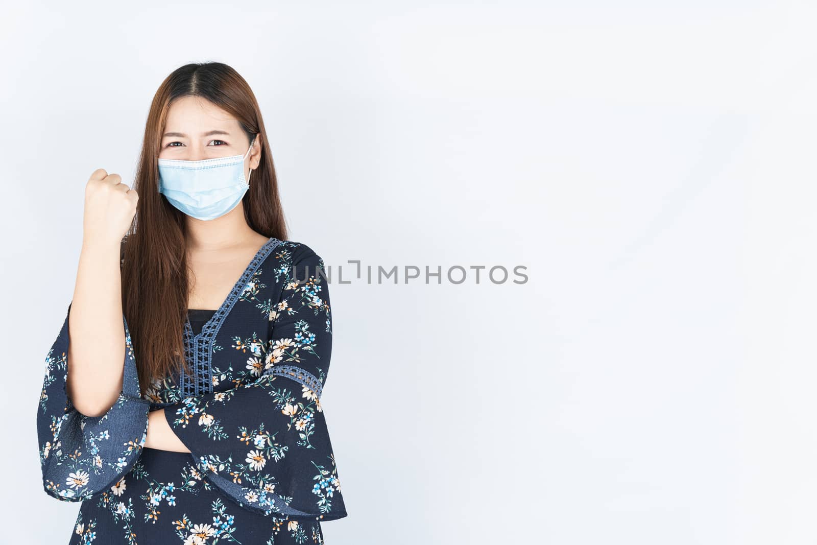 Asian beautiful happy hipster woman wearing a medical protection face mask for protect the coronavirus, filter dust PM 2.5 and cold and raise her hand to fight them on white background