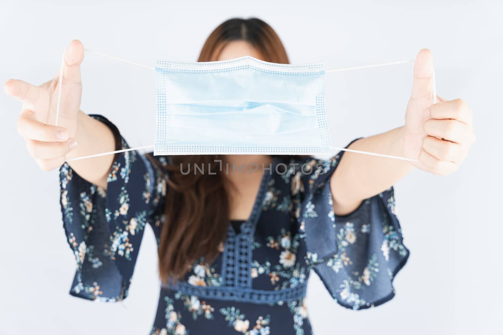 Asian beautiful happy hipster woman showing a medical protection face mask for protect the coronavirus, filter dust PM 2.5 and cold on the white background