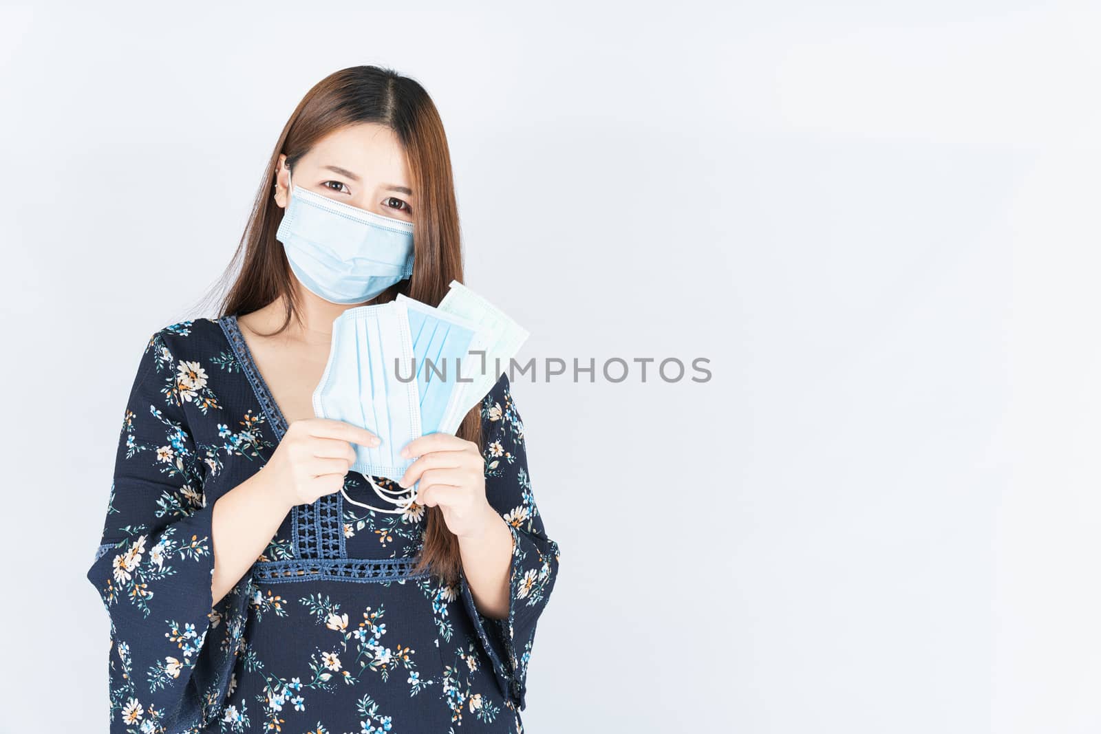 Asian beautiful happy hipster woman showing a medical protection face mask for protect the coronavirus, filter dust PM 2.5 and cold on the white background