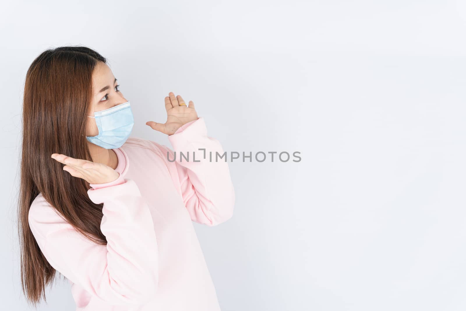 Asian beautiful happy hipster woman wearing a medical protection face mask for protect the coronavirus, filter dust PM 2.5 and cold and raise her hand to cheer up on white background