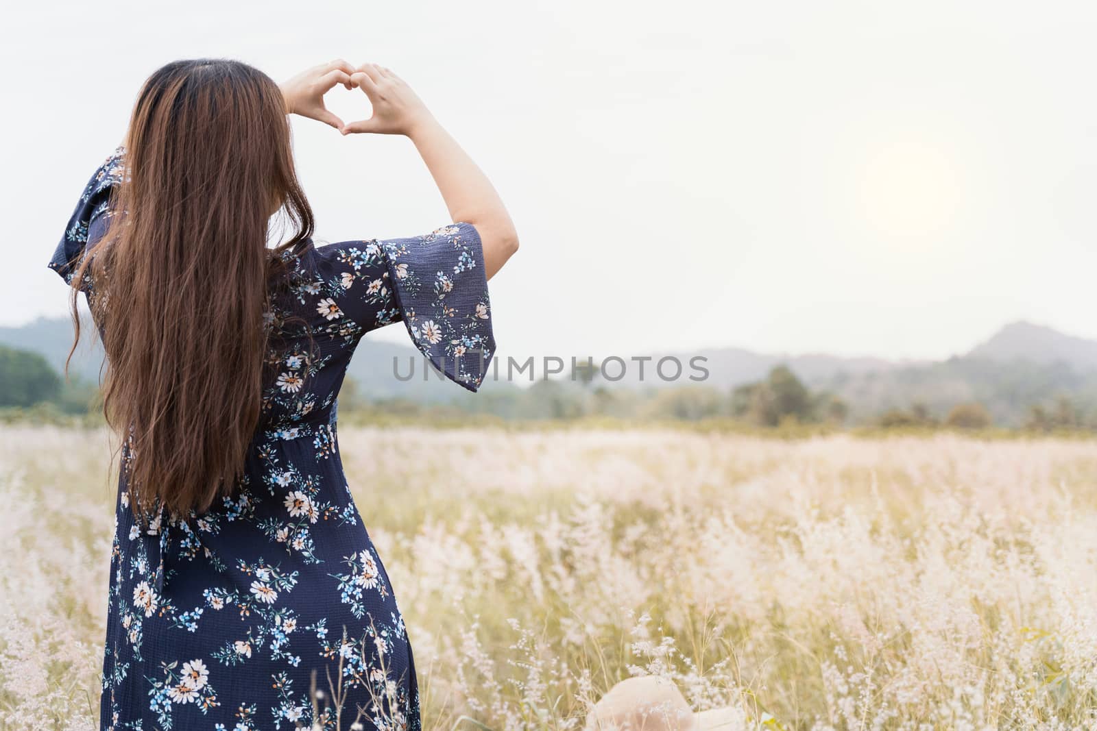 Summer portrait of young hipster woman standing in meadow on sun by mikesaran