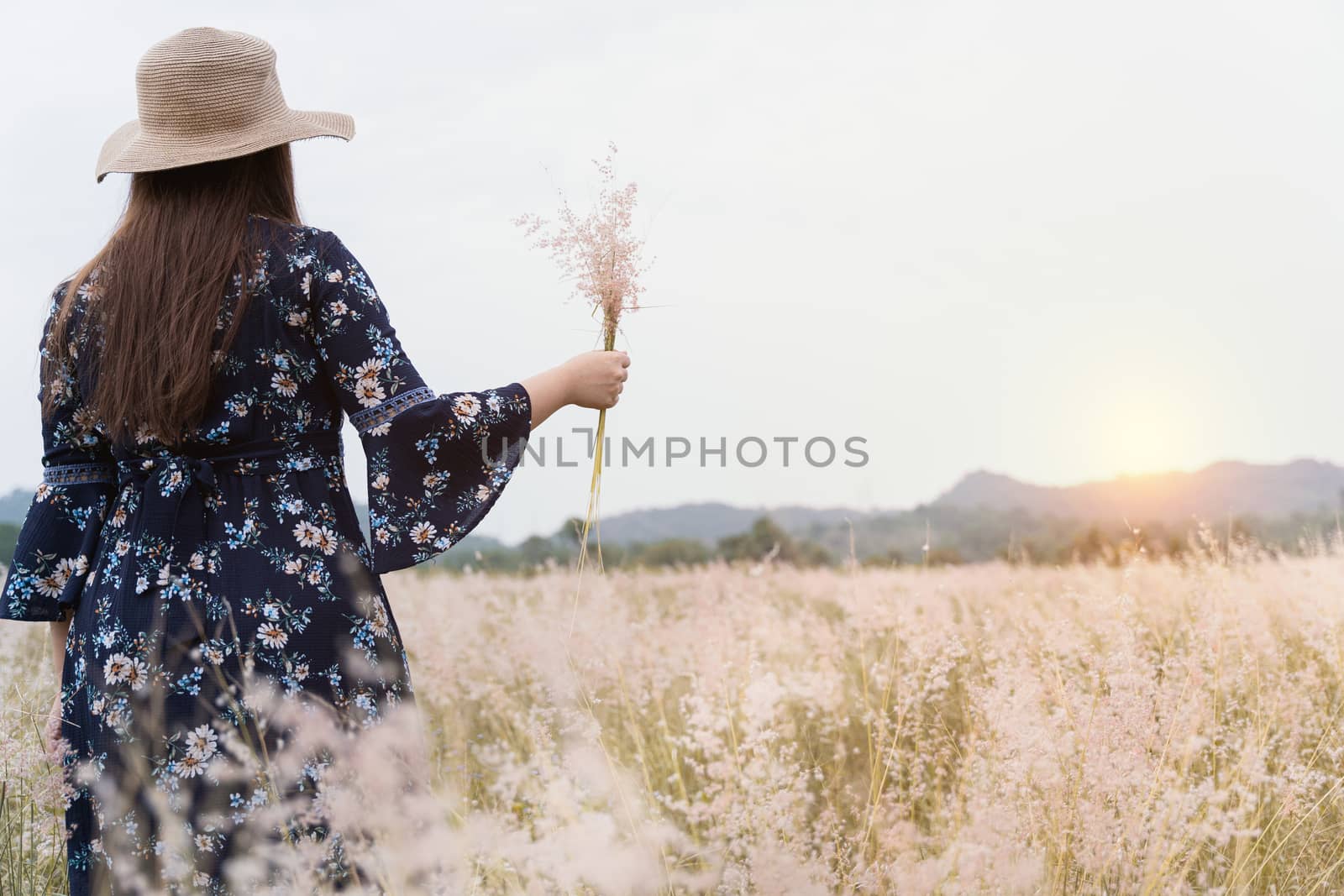 Summer portrait of young hipster woman standing in meadow on sun by mikesaran