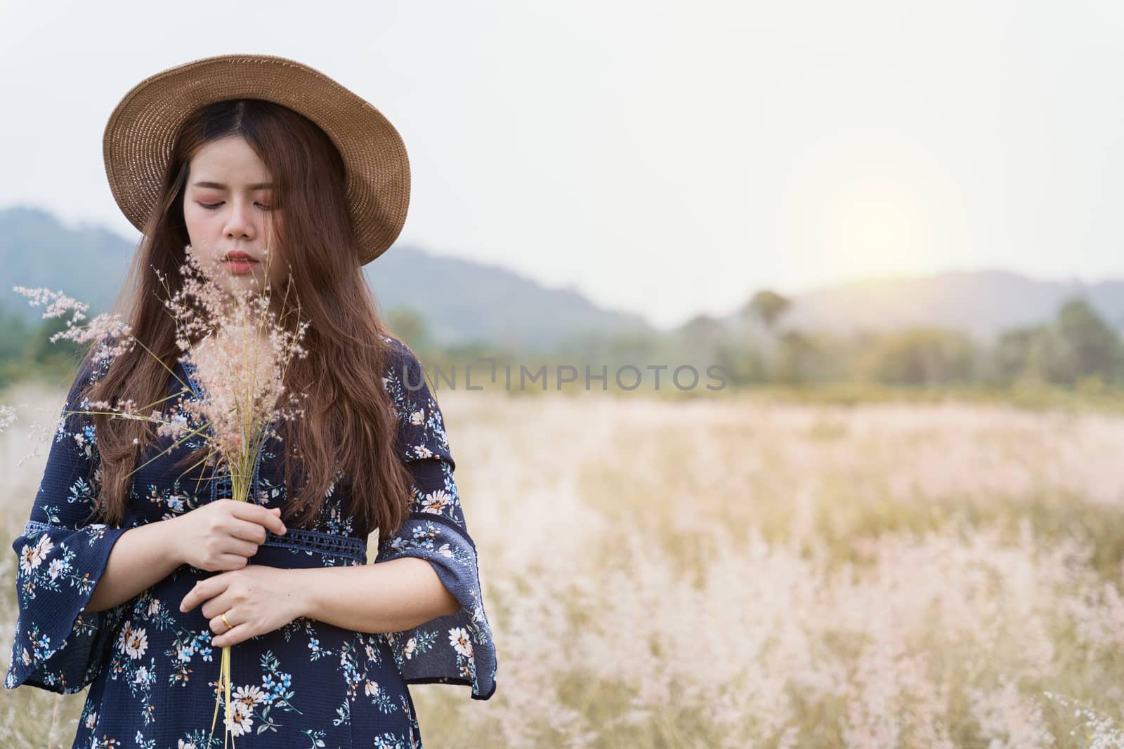 Summer portrait of young hipster woman standing in meadow on sun by mikesaran