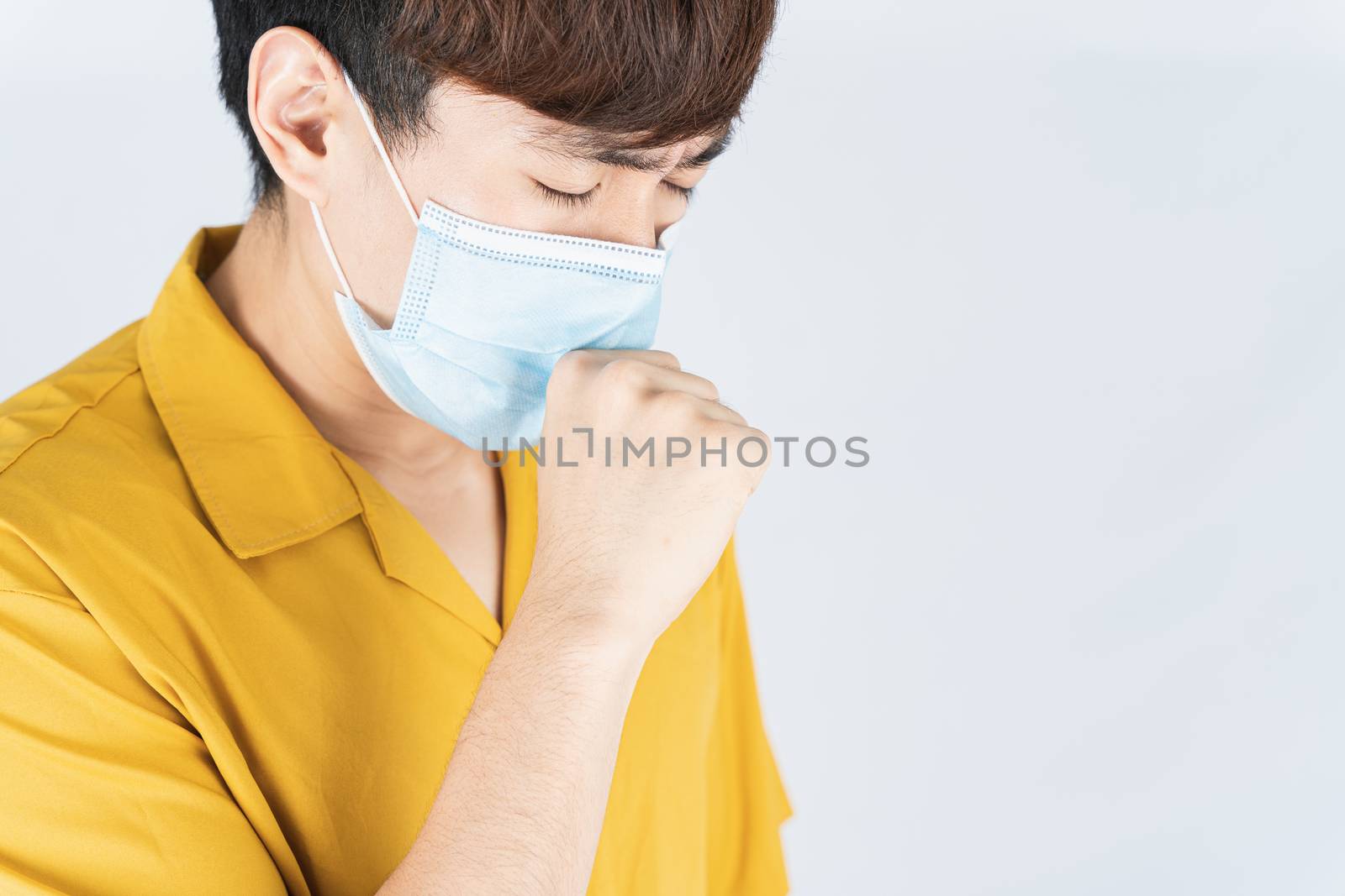 Asian handsome happy hipster man wearing a medical protection face mask for protect the coronavirus, filter dust PM 2.5 and cold and she coughing to mask on white background