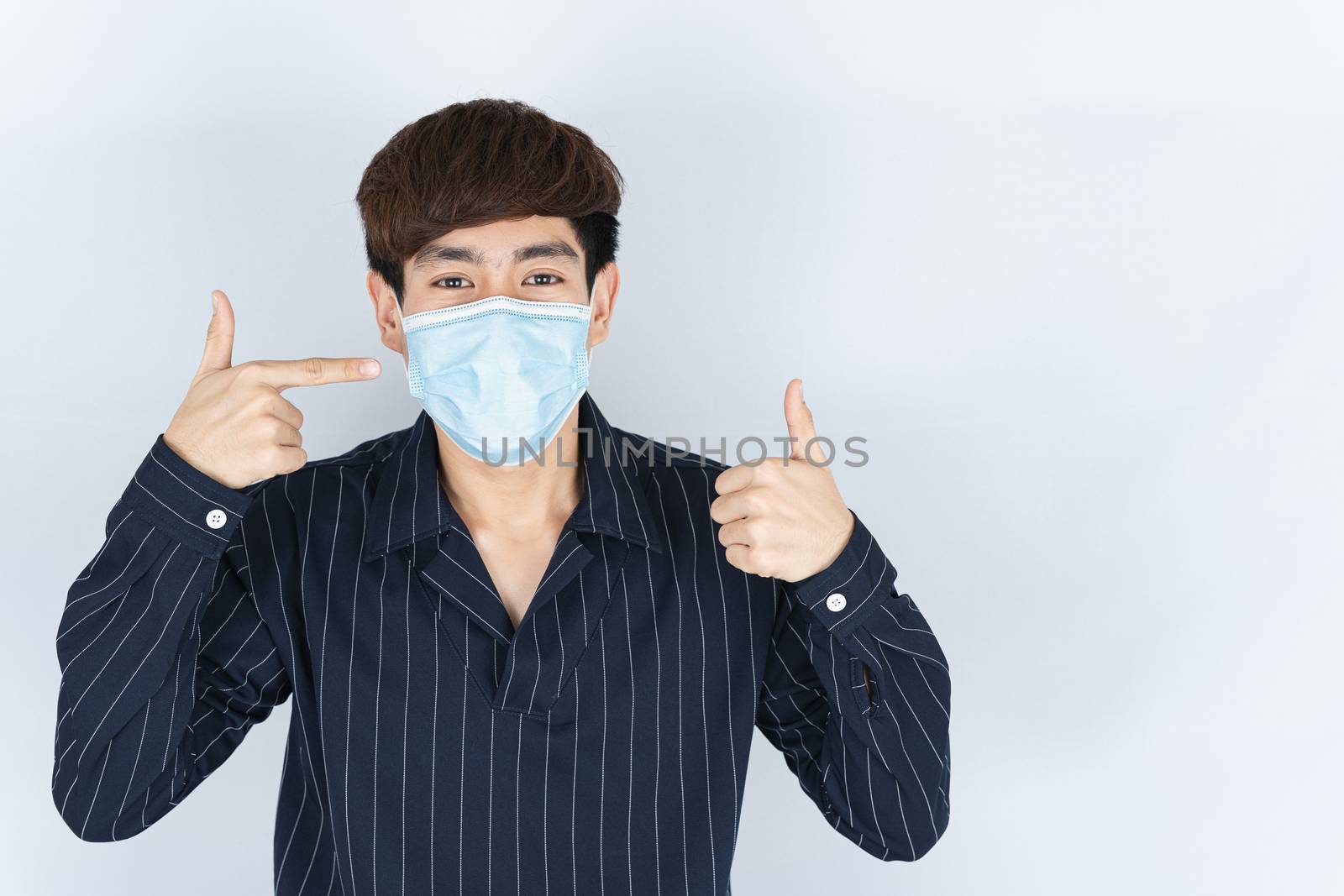 Asian handsome happy hipster man wearing a medical protection fa by mikesaran