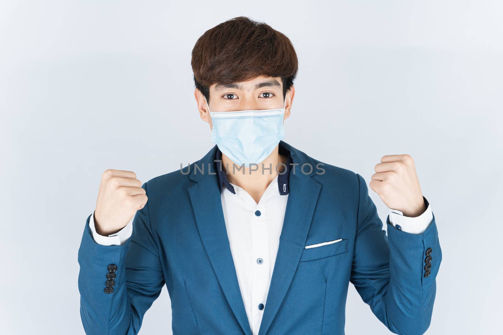 Asian handsome happy business man wearing a medical protection face mask for protect the coronavirus, filter dust PM 2.5 and cold and raise her hand to fight them on white background