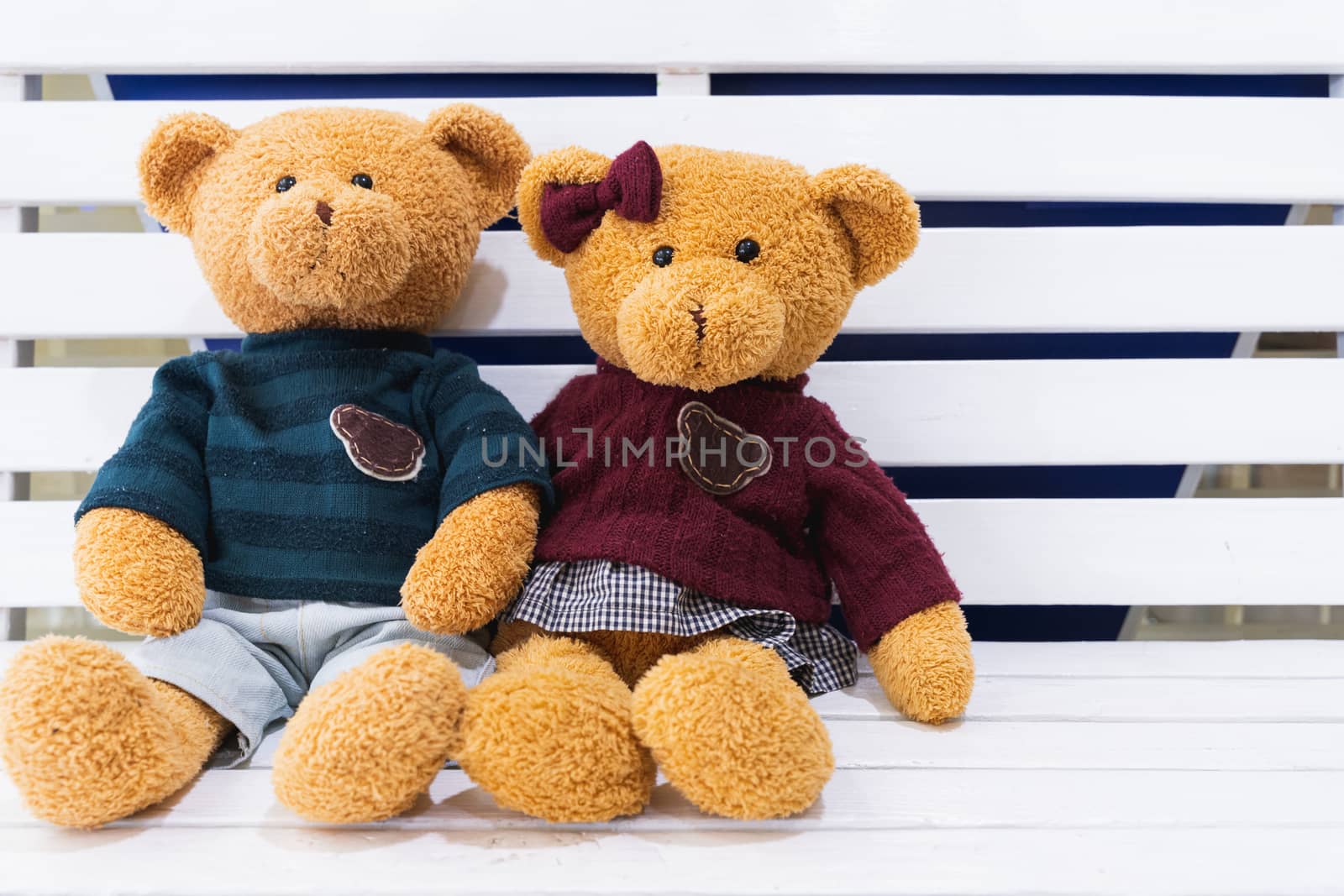 Teddy bears sitting together on the white wooden chair. Valentin by mikesaran