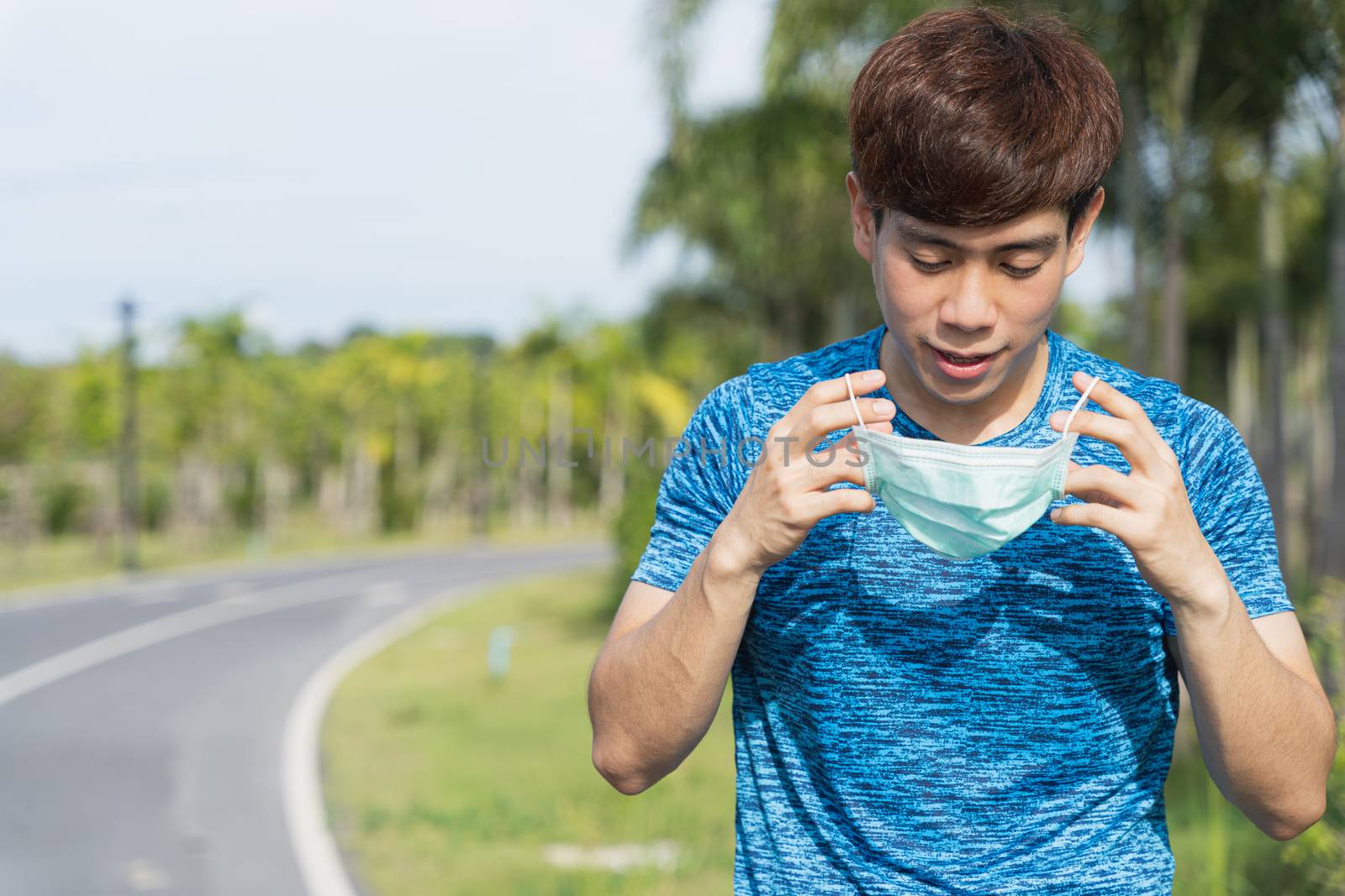 Young male wearing medical mask before workout training session  by mikesaran