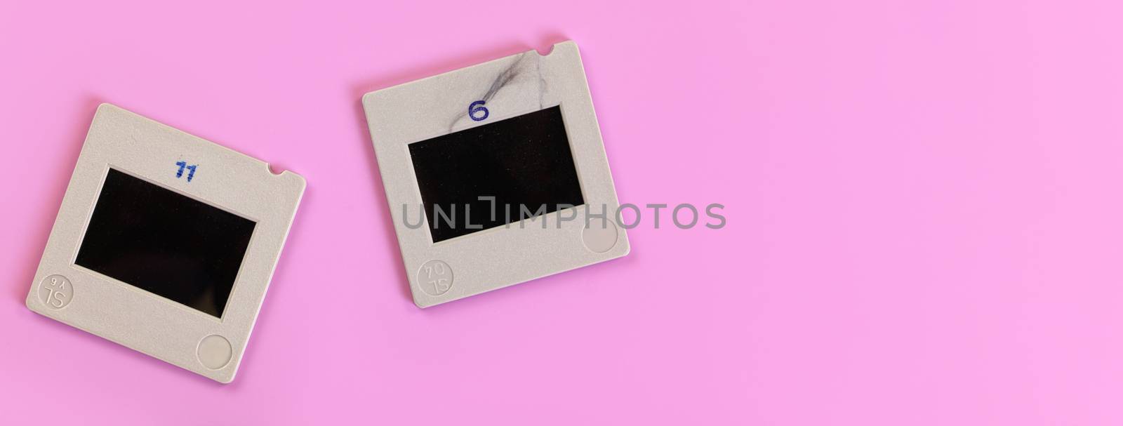 Two diapositive photo slides on pink table, view from above, space for text right side by Ivanko