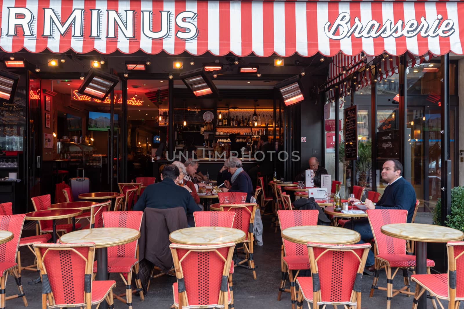 Paris, France -- November 4, 2017 -- Wide angle shot of Parisians dining in outdoors  in a brasserie on a pleasant Autumn afternoon. Editorial Use Only