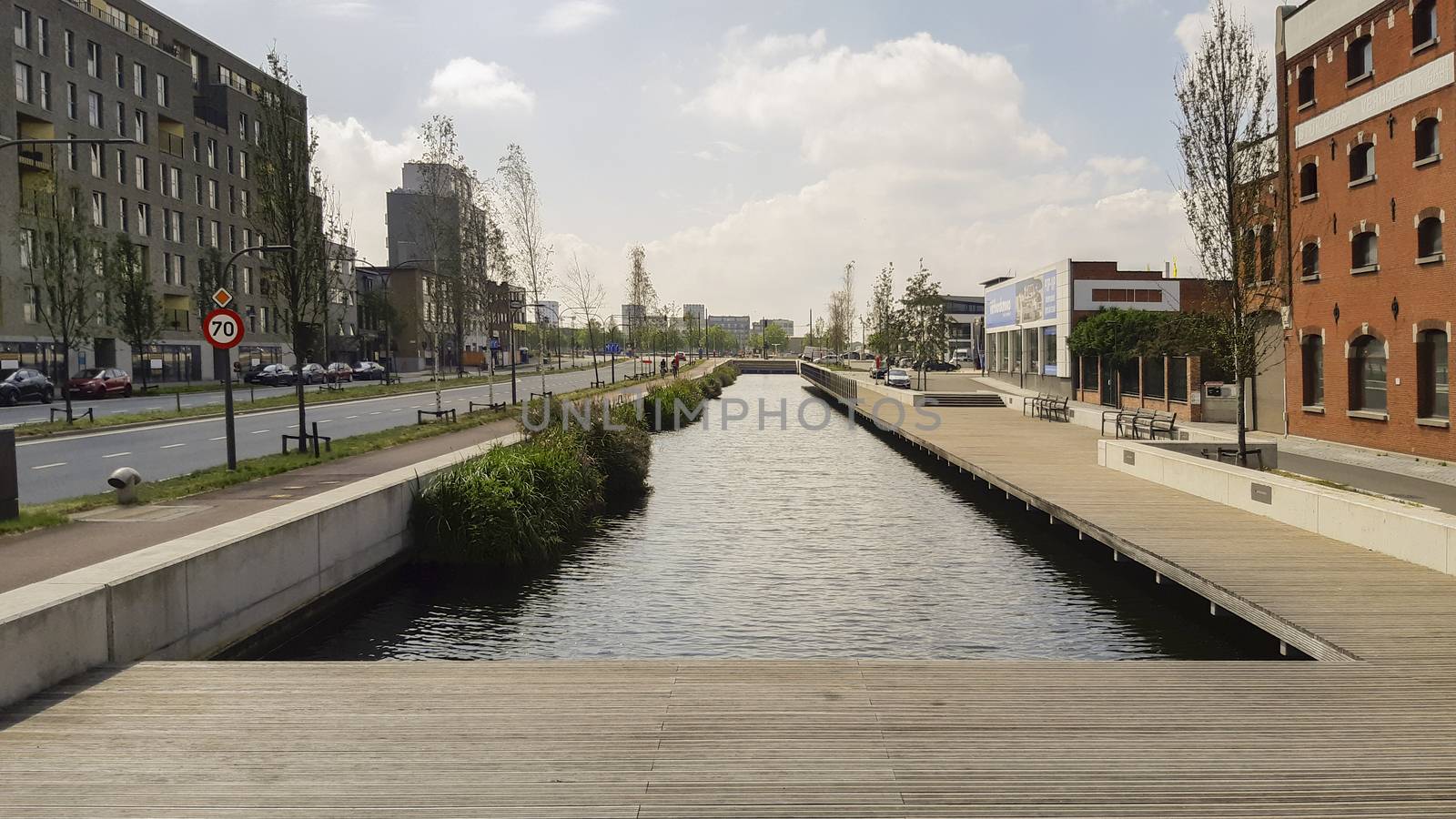 Antwerp, Belgium, July 2020: wooden walkway and esplanade on the canal on the IJzerlaan in Antwerp, Belgium. City renewal project. Canal connecting Lobroekdok and Asiadok.