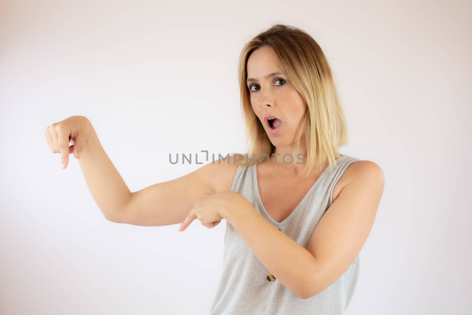 Young woman with short hair wearing a casual dress pointing with her fingers