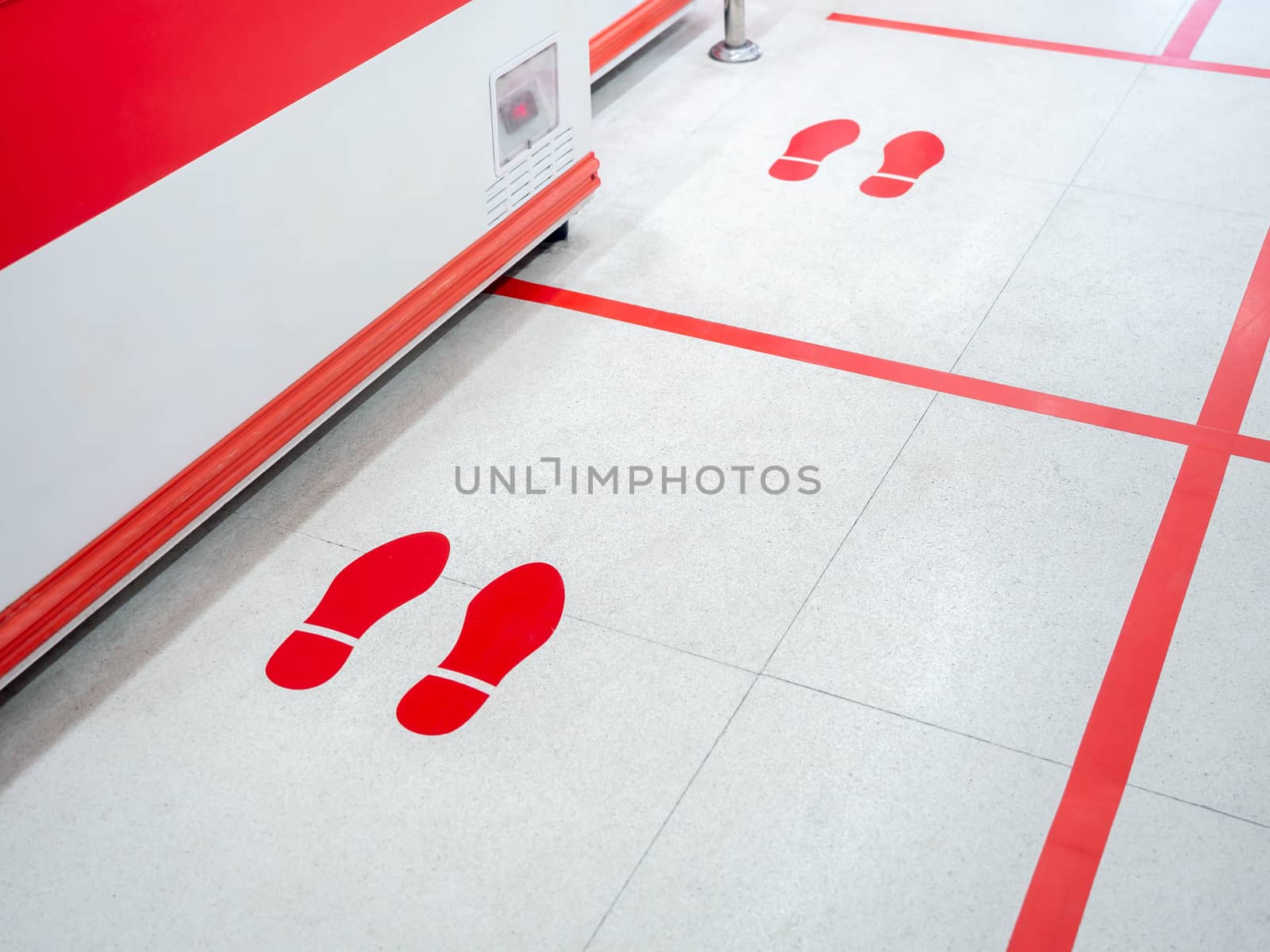 Red footprint and red line on floor in supermarket for warning for keep a safe social distance protect from Coronavirus, social distancing concept.