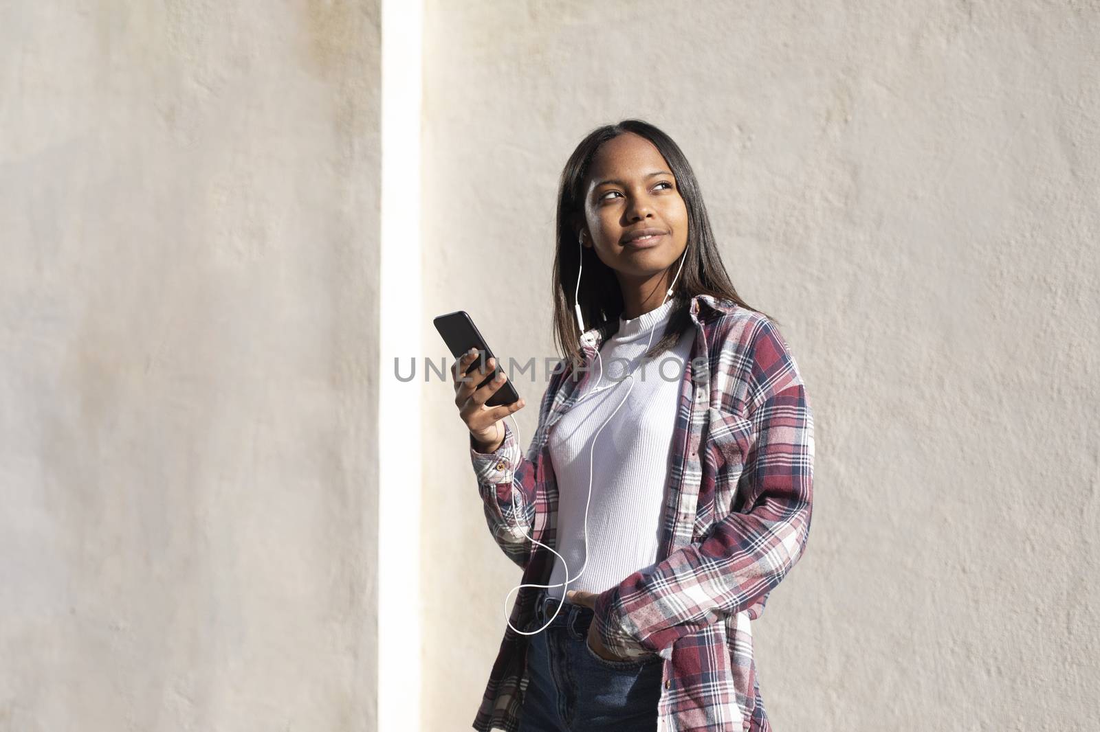 Portrait of African American young woman standing on the street while using a mobile phone