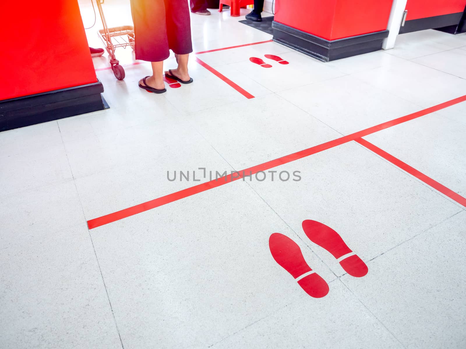 Red footprint and red line on floor in supermarket for warning for keep a safe social distance protect from Coronavirus, social distancing concept.