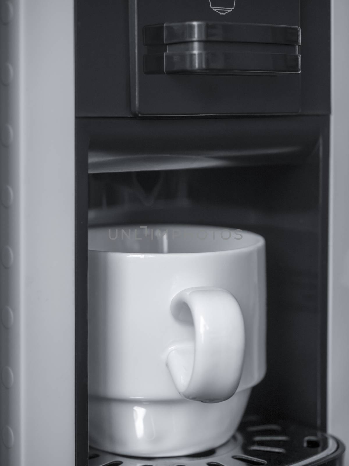 White ceramic coffee cup on coffee machine, vertical style.