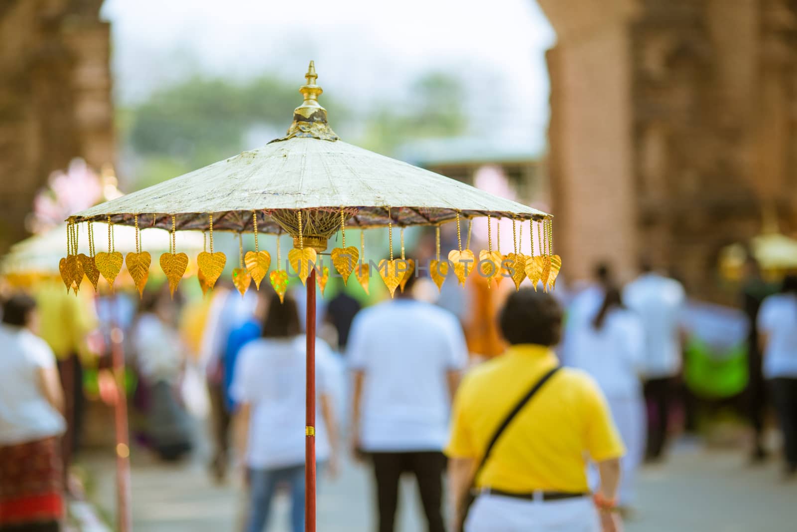 An umbrella that is decorated with golden leaves.