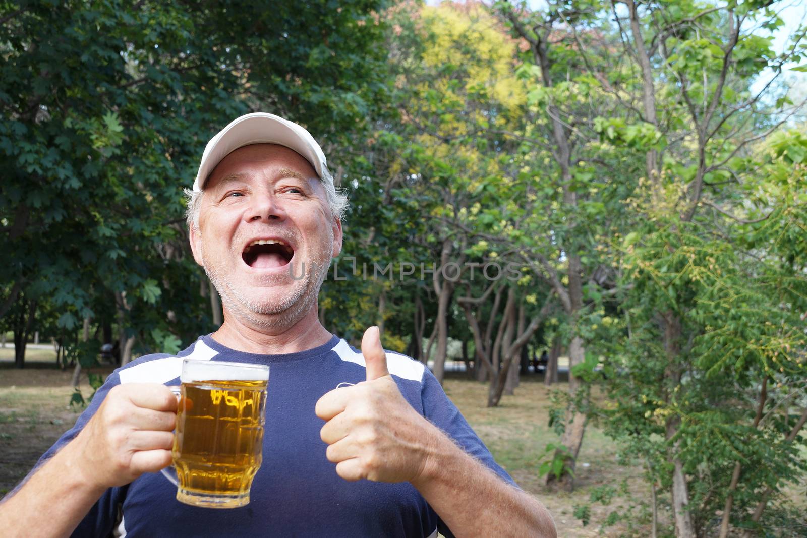 a laughing man holds a mug of beer in one hand, with the other hand shows that everything is fine by Annado
