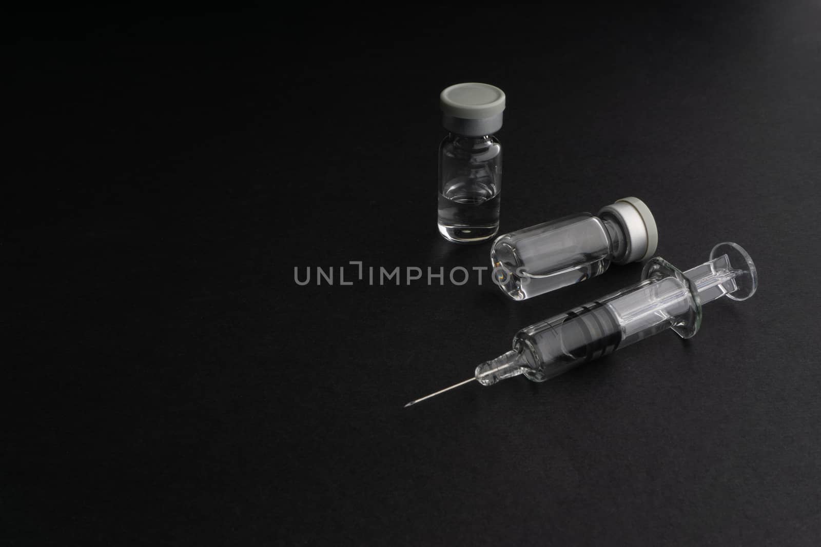 Closeup syringe and vials on black background by silverwings