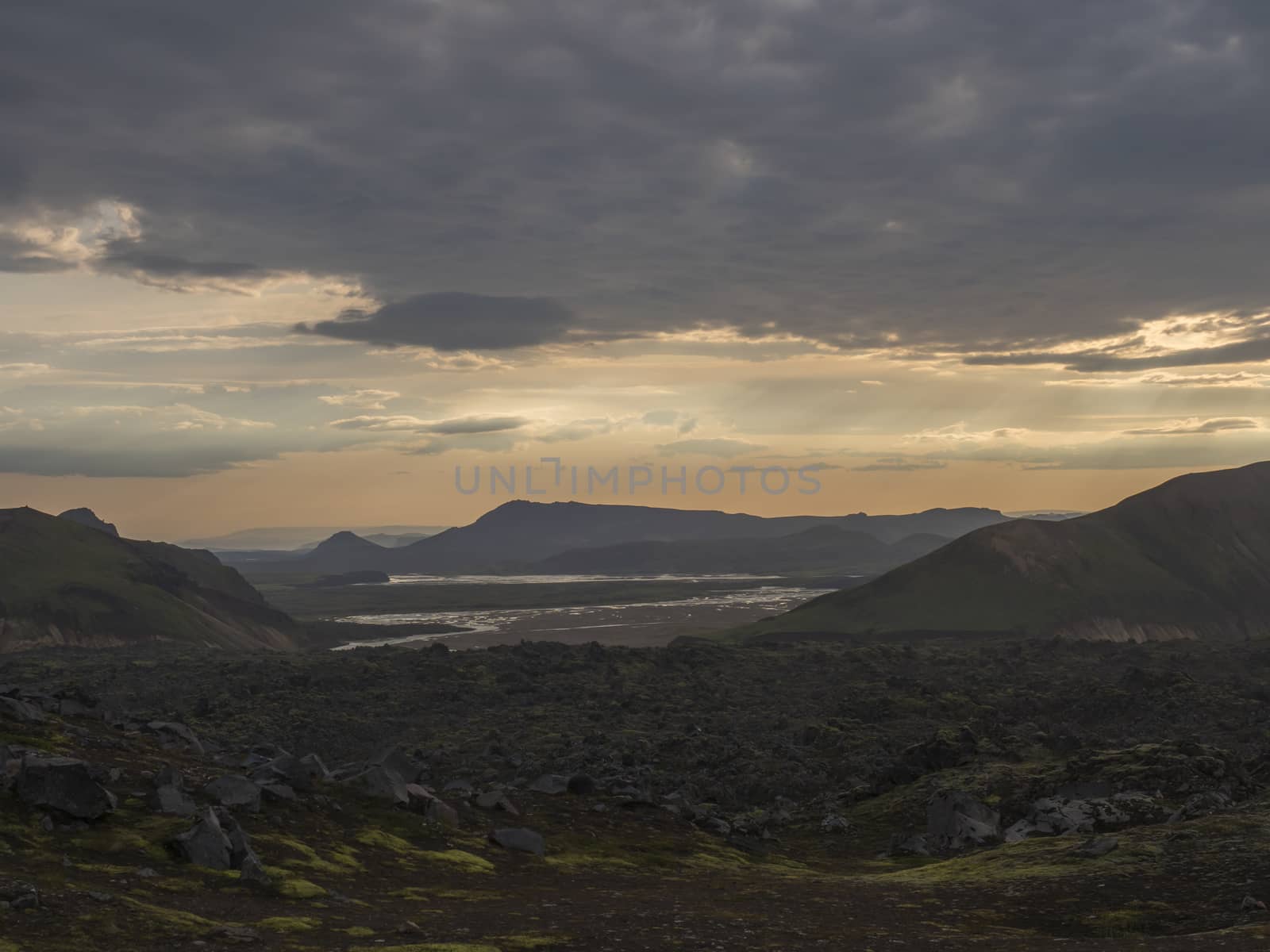 Lava field landscape in Landmannalaugar with river delta and Rhyolit mountain at Sunrise in Fjallabak Nature Reserve, Highlands Iceland.