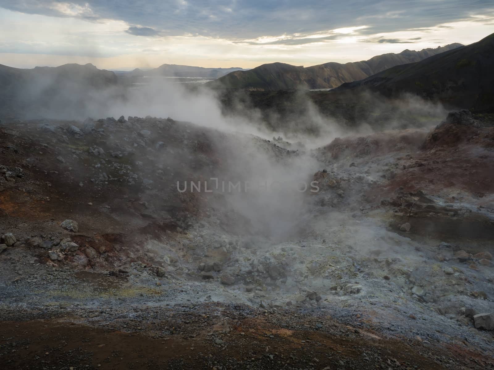 Geothermal fumarole and colorful Rhyolit mountain with multicolored volcanos. Sunrise in Landmannalaugar at Fjallabak Nature Reserve, Highlands Iceland.