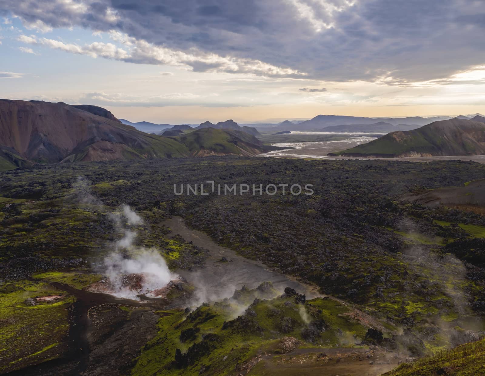 Colorful Rhyolit mountain panorma with multicolored volcanos and geothermal fumarole and river delta. Sunrise in Landmannalaugar at Fjallabak Nature Reserve, Highlands Iceland.