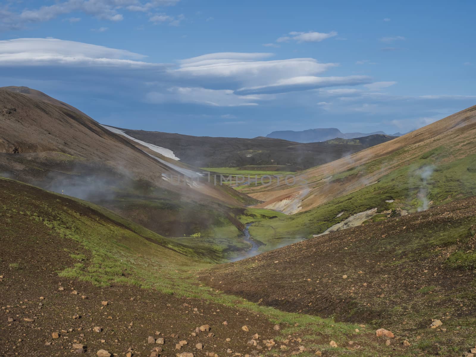 Landmannalaugar colorful Rhyolit mountains with steam from hot spring on famous Laugavegur trek. Fjallabak Nature Reserve in Highlands of Iceland, summer blue sky