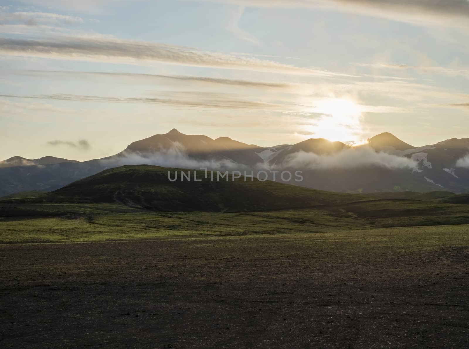 Sunrise at Alftavatn camping site with snow covered mountains and green hills. Landscape of the Fjallabak Nature Reserve in the Highlands of Iceland.