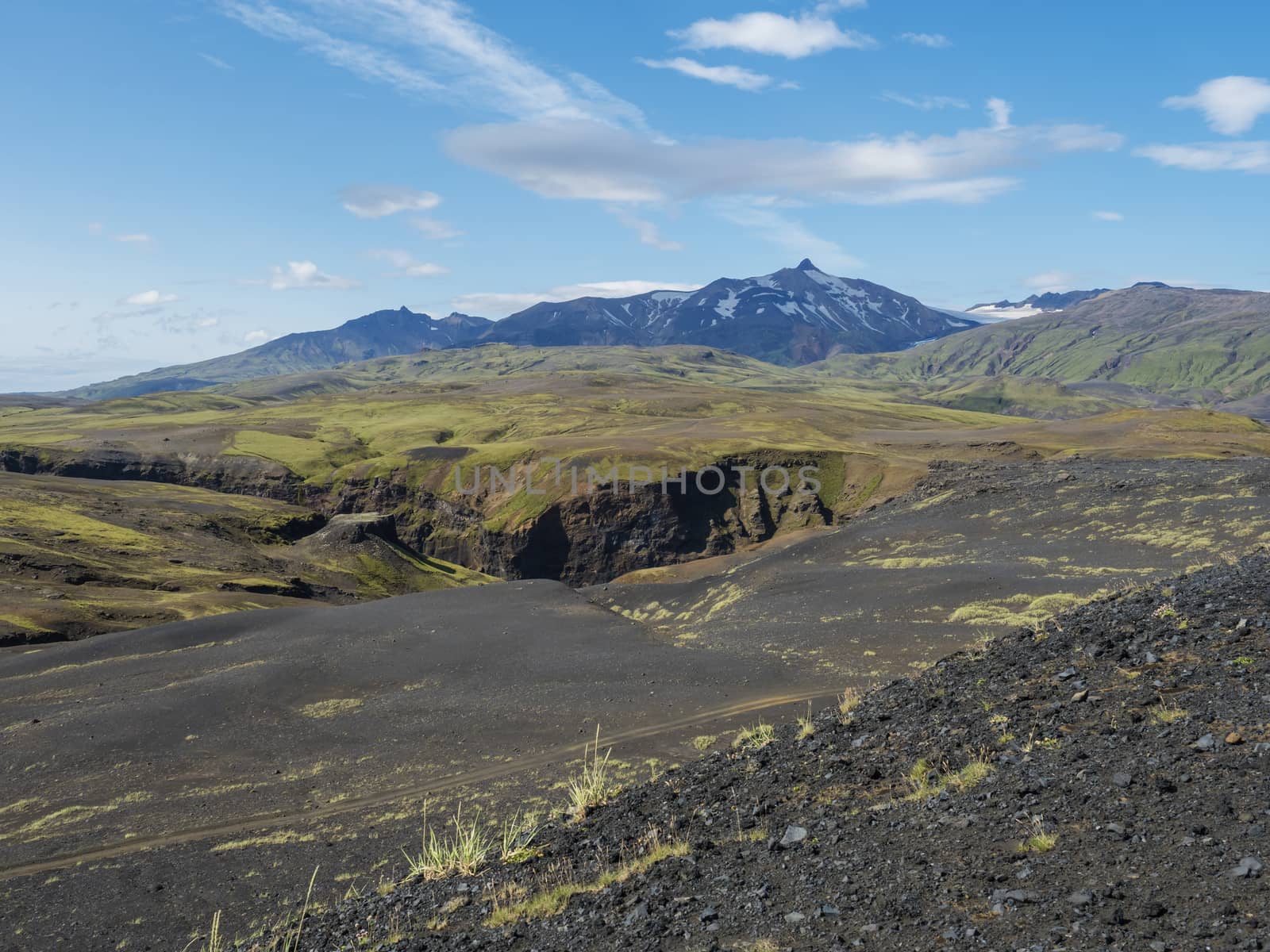 Icelandic lava desert landscape with view on Tindfjallajokull glacier mountain peak. Fjallabak Nature Reserve, Iceland. Summer blue sky.