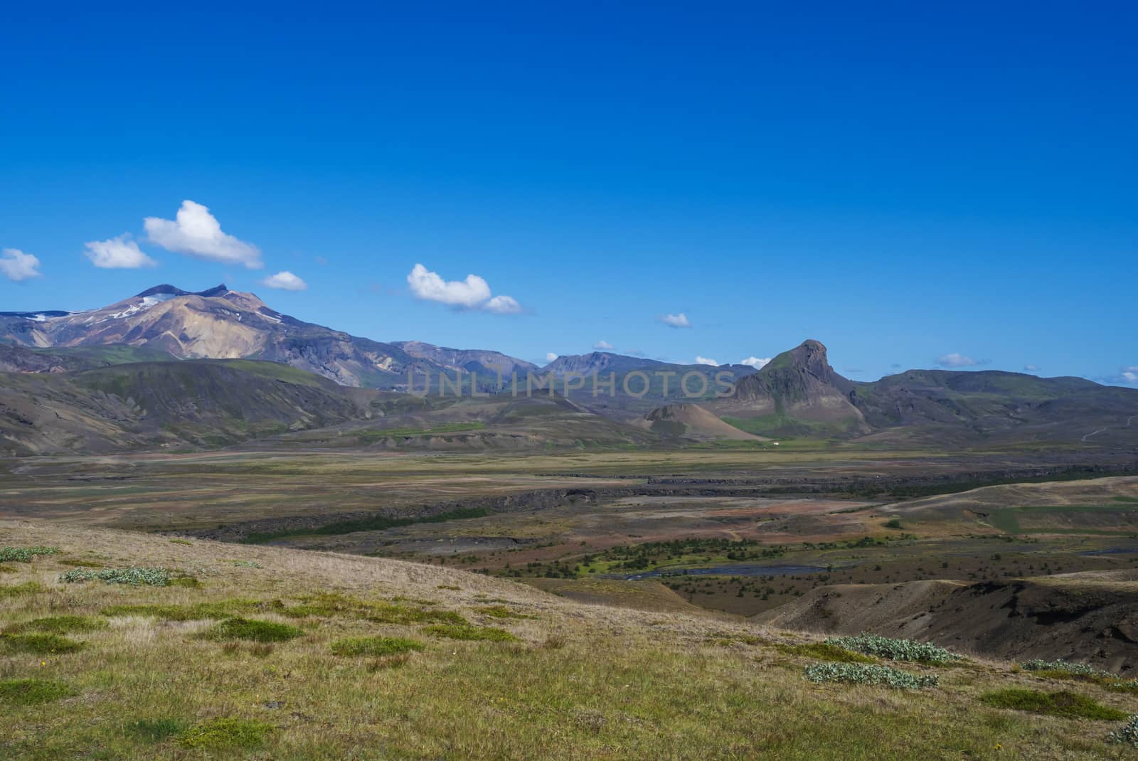 Icelandic landscape with blue Markarfljot river canyon, colorful Landmannalaugar mountain, birch bush, green hills and meadows. Laugavegur hiking trail. Fjallabak Nature Reserve, Iceland. Summer blue sky.