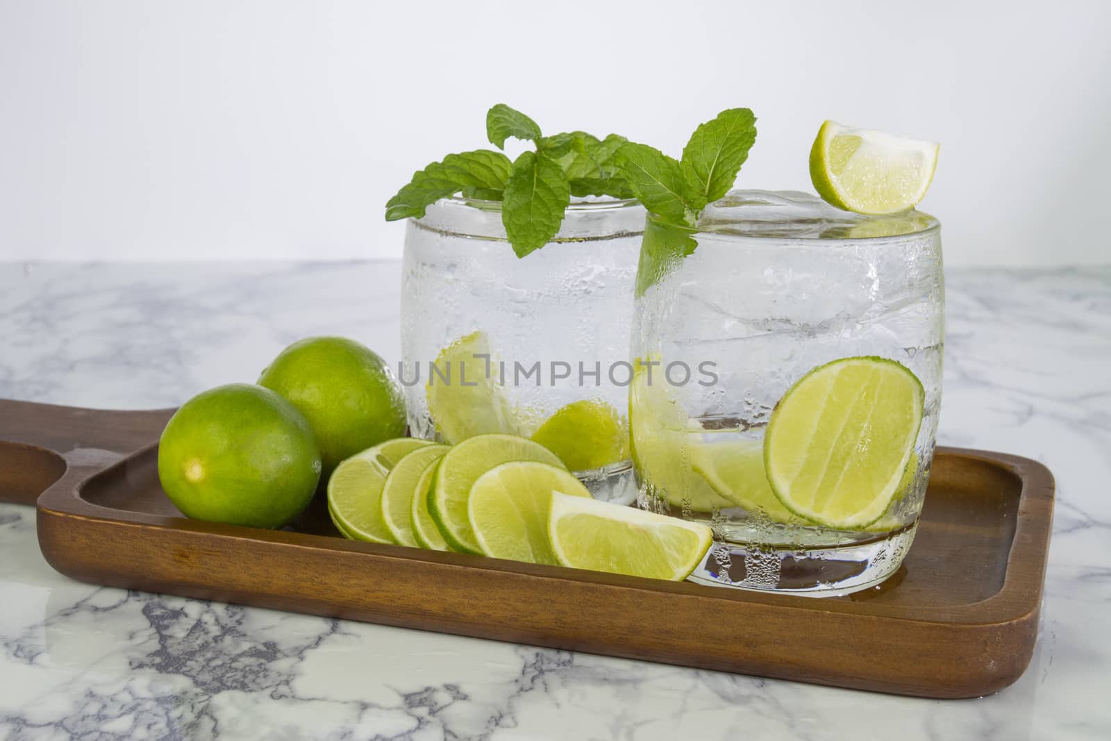 Cold Drink from Lemon cut into pieces in water glass on wood cup