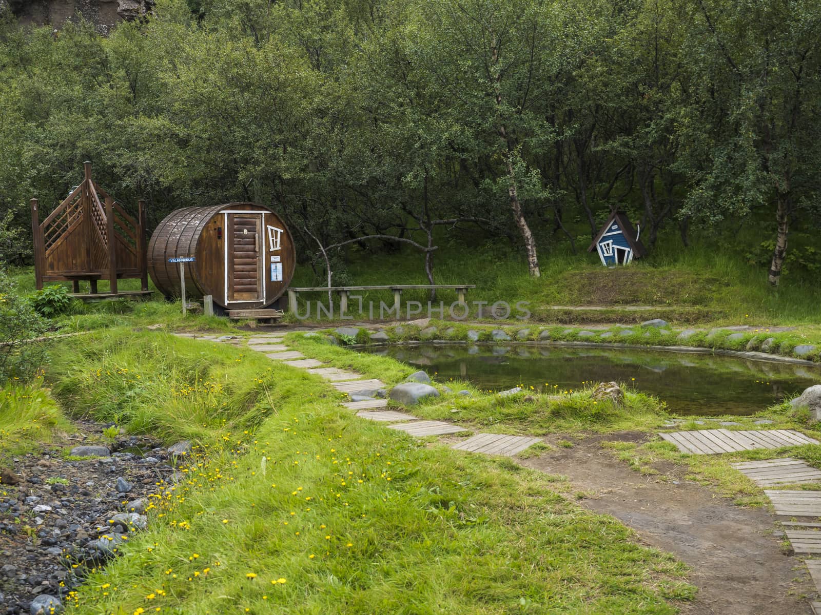 Geothermal hot pool with sauna at the Husadalur Camp in the birch forest in Thorsmork valley, Iceland.
