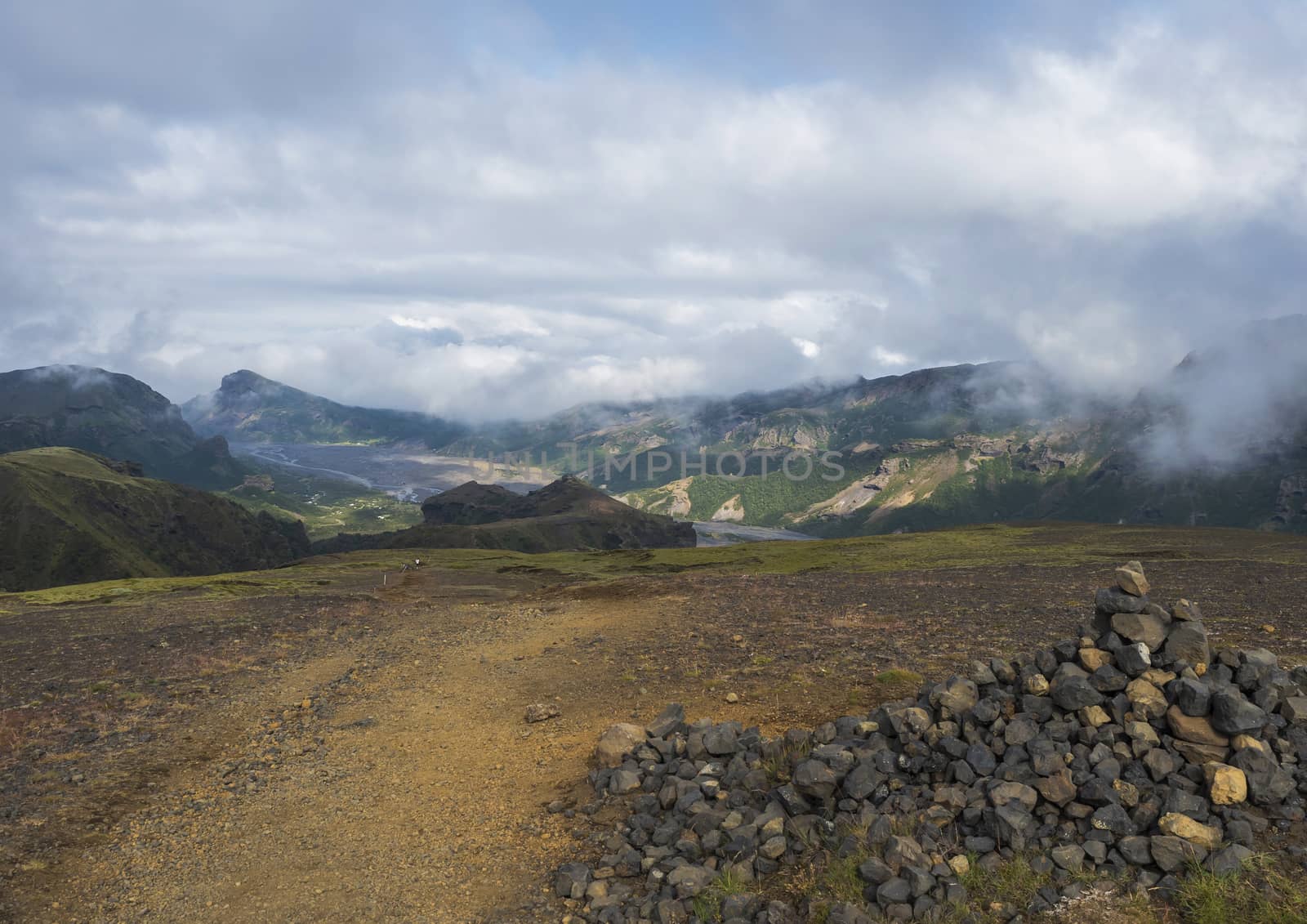 Landscape of Godland and thorsmork with stone pile, rugged green moss covered rocks and hills, bending river canyon, Iceland, Fimmvorduhals hiking trail. Summer cloudy day