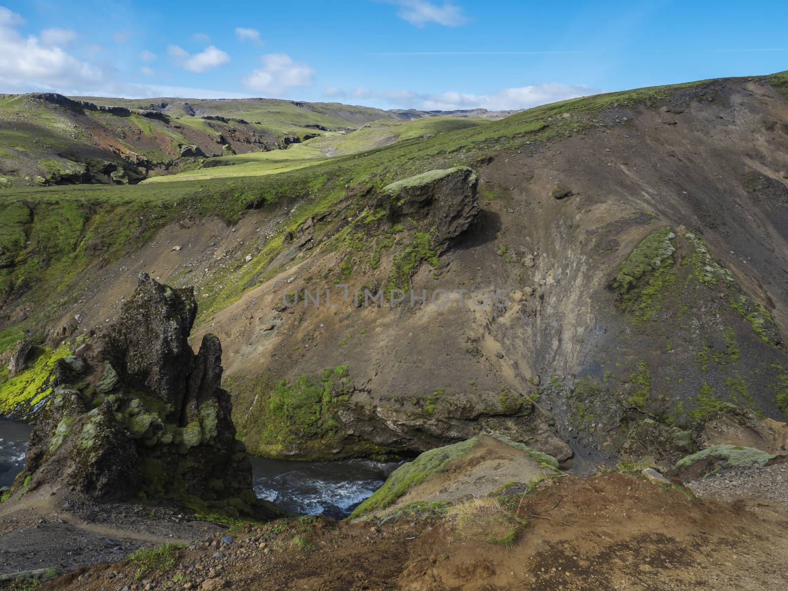 Beautiful lush green Landscape of Skoga river valley cascades near Skogafoss waterfall and Skogar end of Fimmvorduhals hiking trail. South Iceland, Summer blue sky.