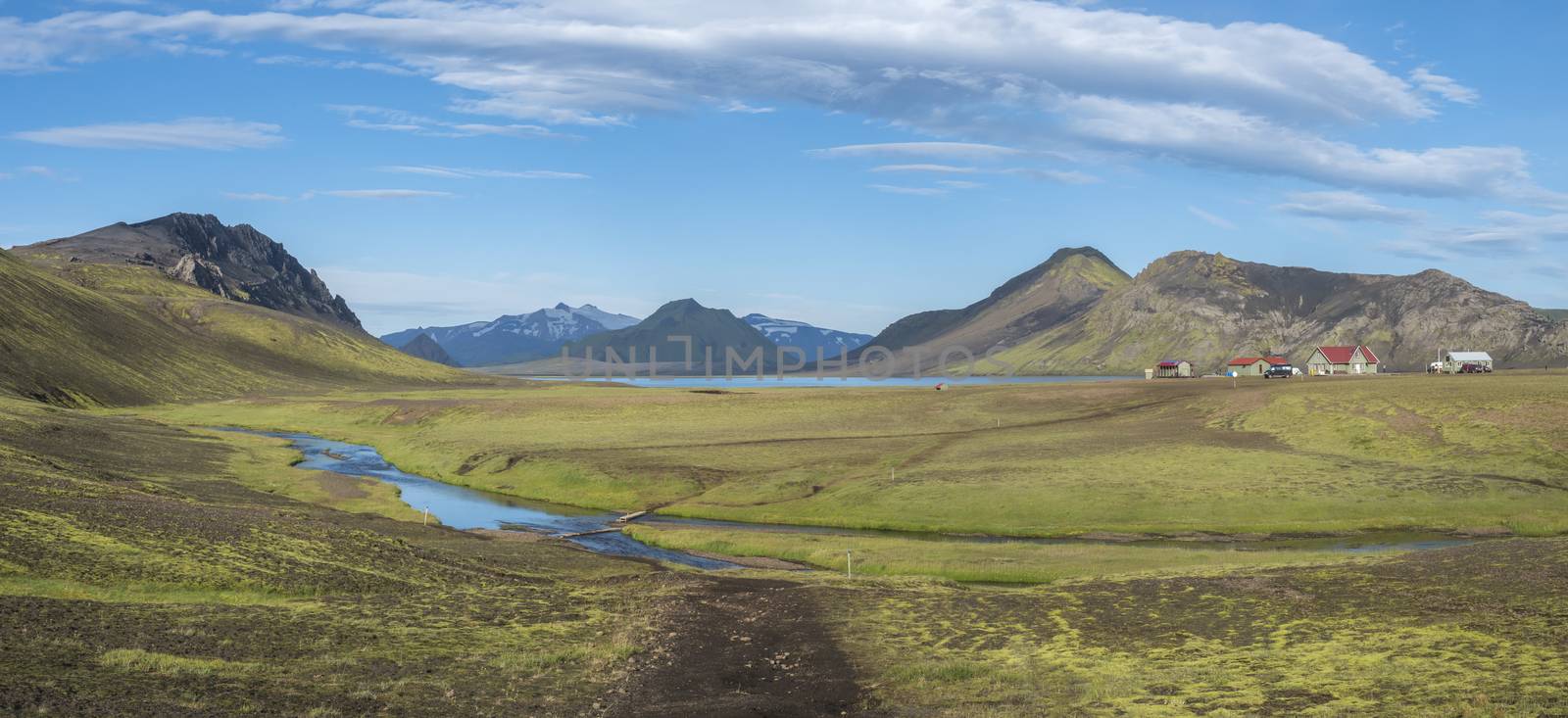 Panoramic landscape with mountain huts at camping site on blue Alftavatn lake with river, green hills and glacier in beautiful landscape of the Fjallabak Nature Reserve in the Highlands of Iceland part of Laugavegur hiking trail. by Henkeova