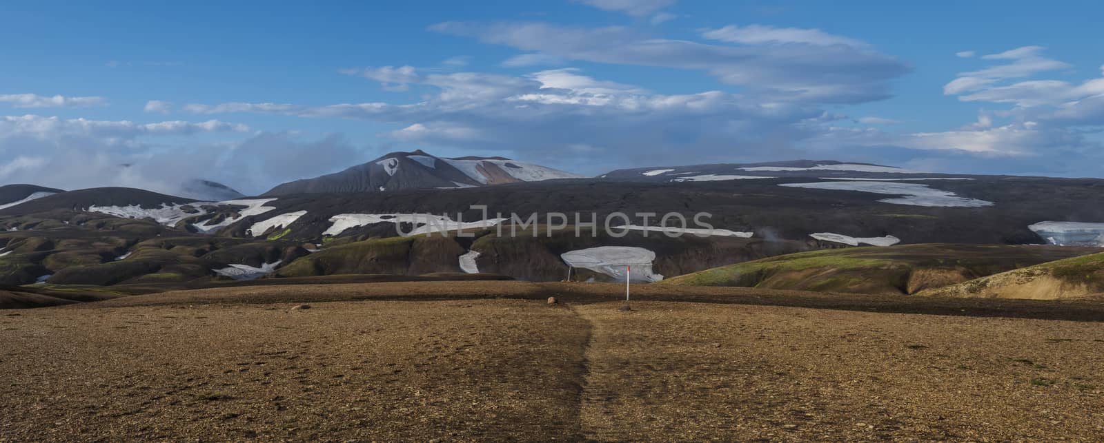 Colorful Rhyolit Landmannalaugar mountain panorma with multicolored volcanos and footpath of Laugavegur trek in at Fjallabak Nature Reserve, Highlands Iceland. Summer sunny day, blue sky background.