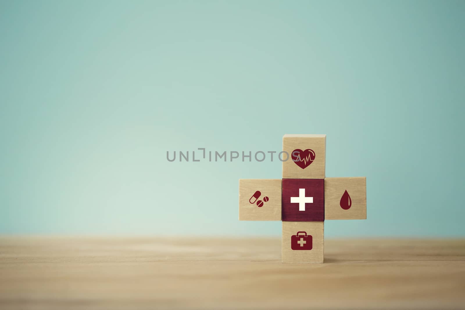 Healthcare concept about of health and medical insurance, arranging wood block stacking with icon healthcare medical on table wooden background.
