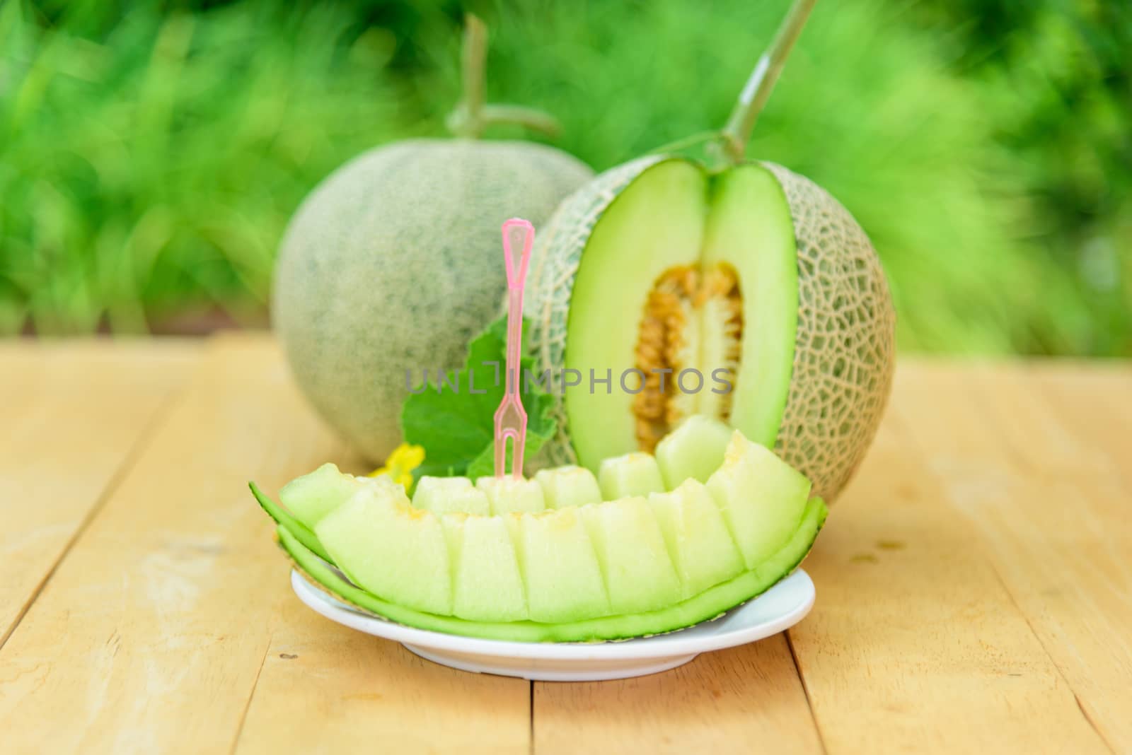 Fresh green melon on wood plate