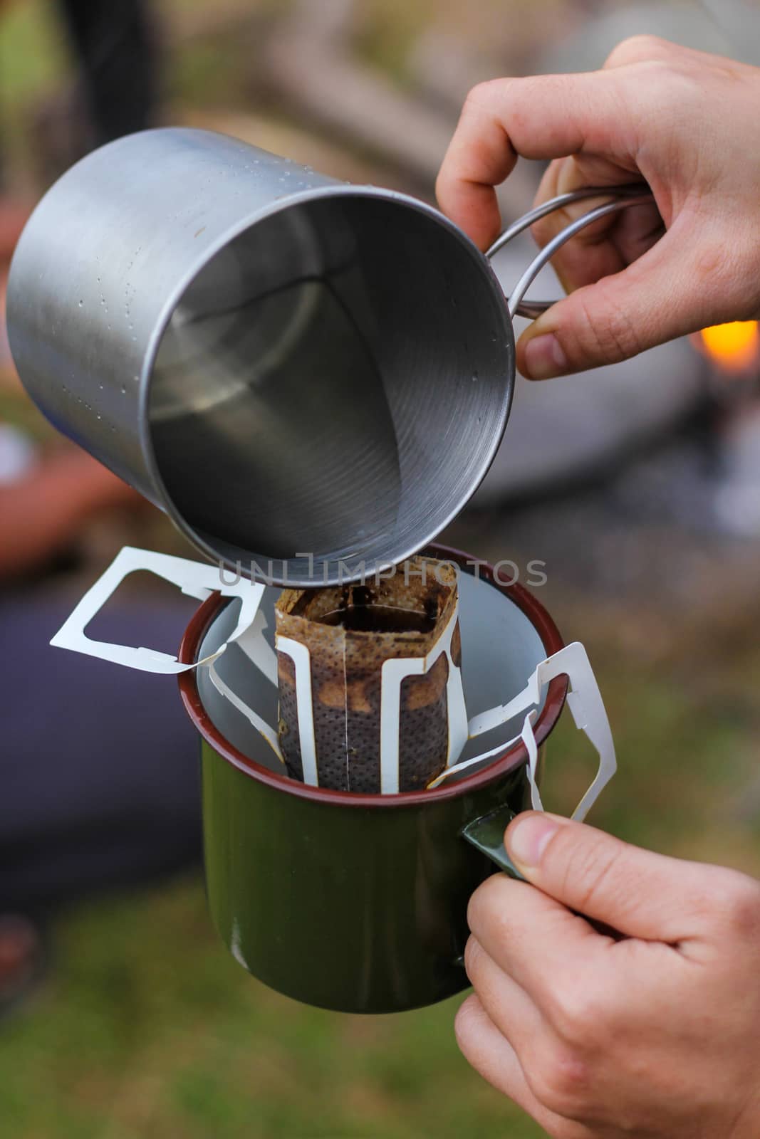 Pour hot water into a bag of drip coffee. by suthipong