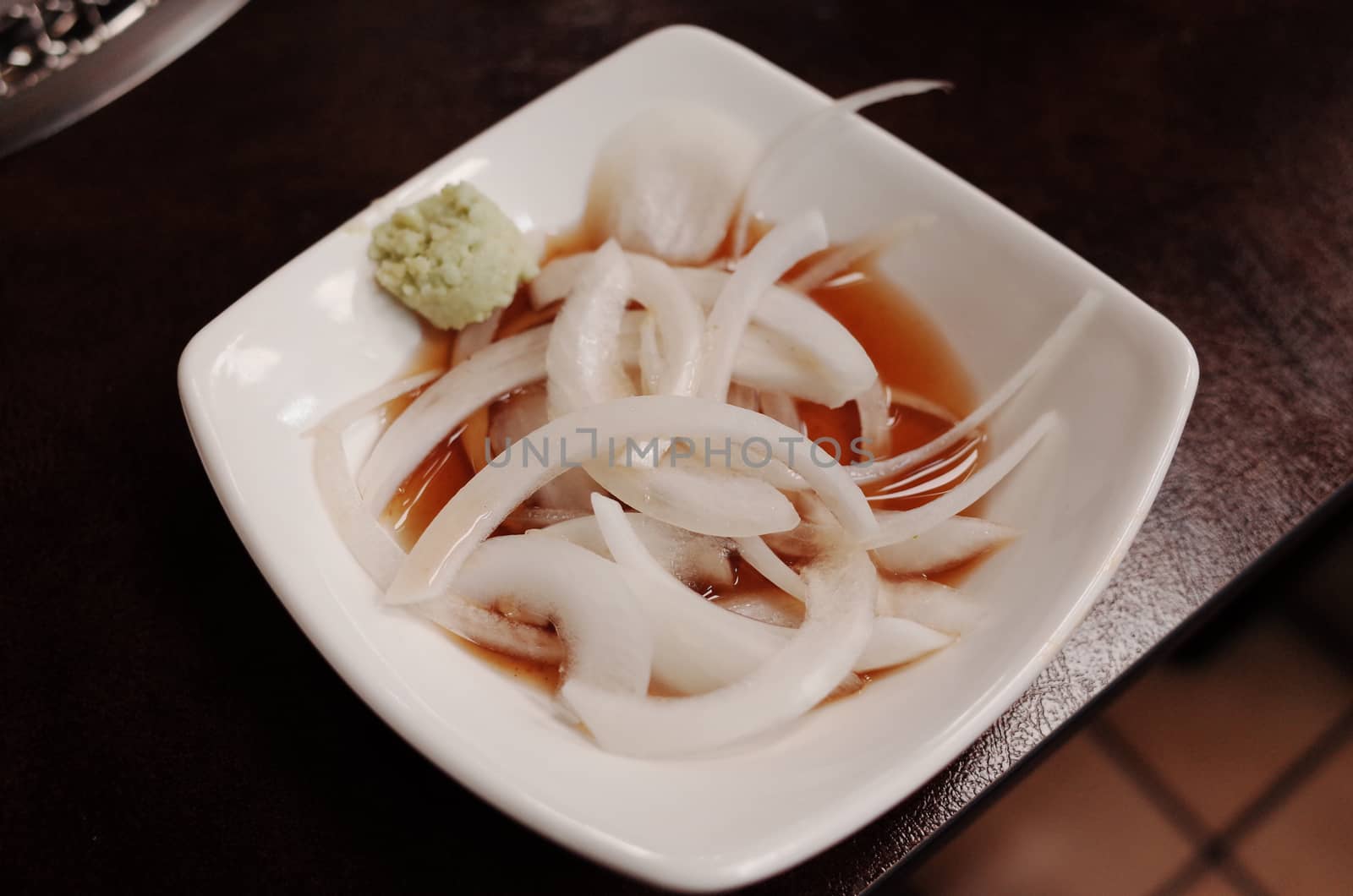 Pickled onions on white plate by uphotopia