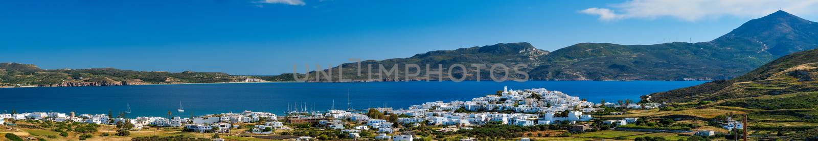 View of Plaka village with traditional Greek church and white painted houses and ocean coast. Milos island, Greece