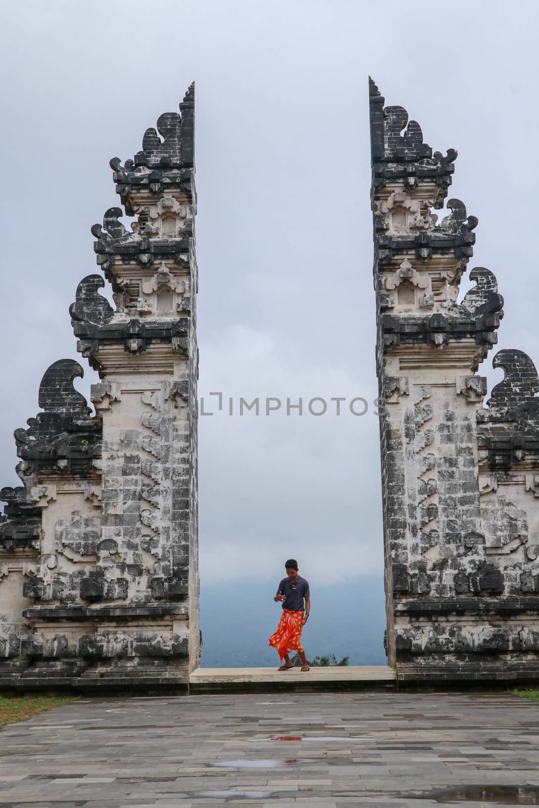 Teenager is standing in the gate of Lempuyang temple on Bali isalnd, Indonesia.